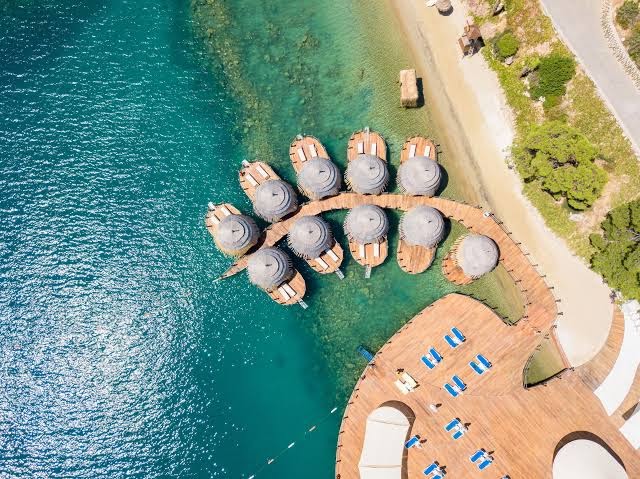 Skats no augšas uz La Blanche Island Bodrum ekskluzīvajiem bungalo virs ūdens un koka laipu atpūtas zonu