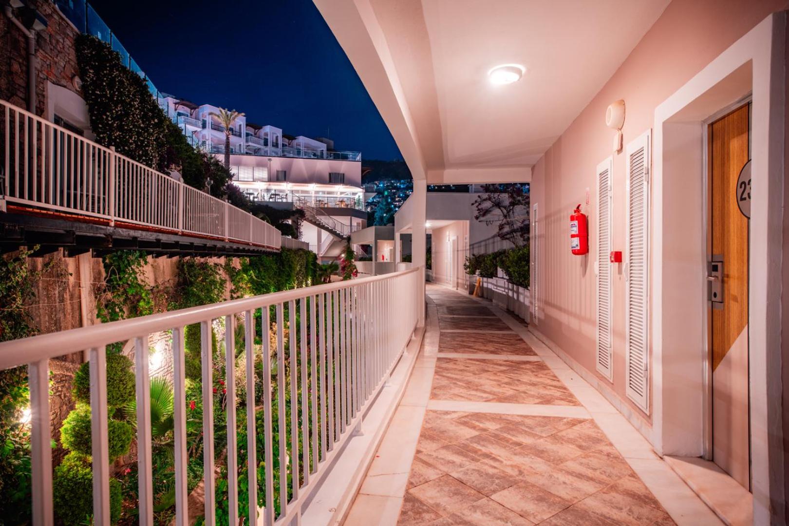 Hotel Baia Bodrum viesnīcas korpusa gaitenis naktī ar skatu uz terasveida apbūvi un dārzu Bodrumā
