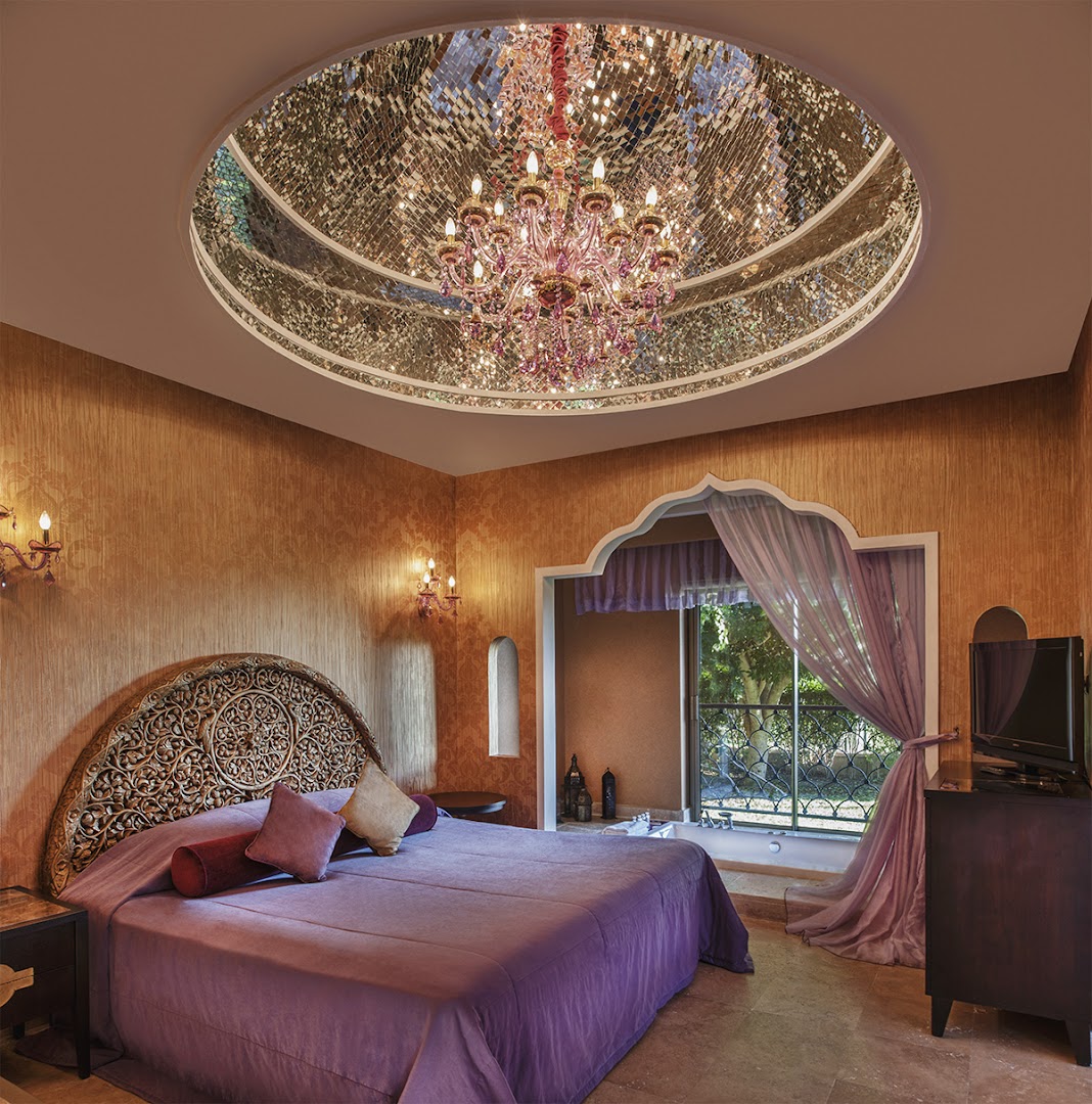 Spice Hotel & Spa grezns numurs ar austrumniecisku dizainu, lielu gultu, masīvu koka galvgali un spoguļu kupolu pie griestiem Belekā