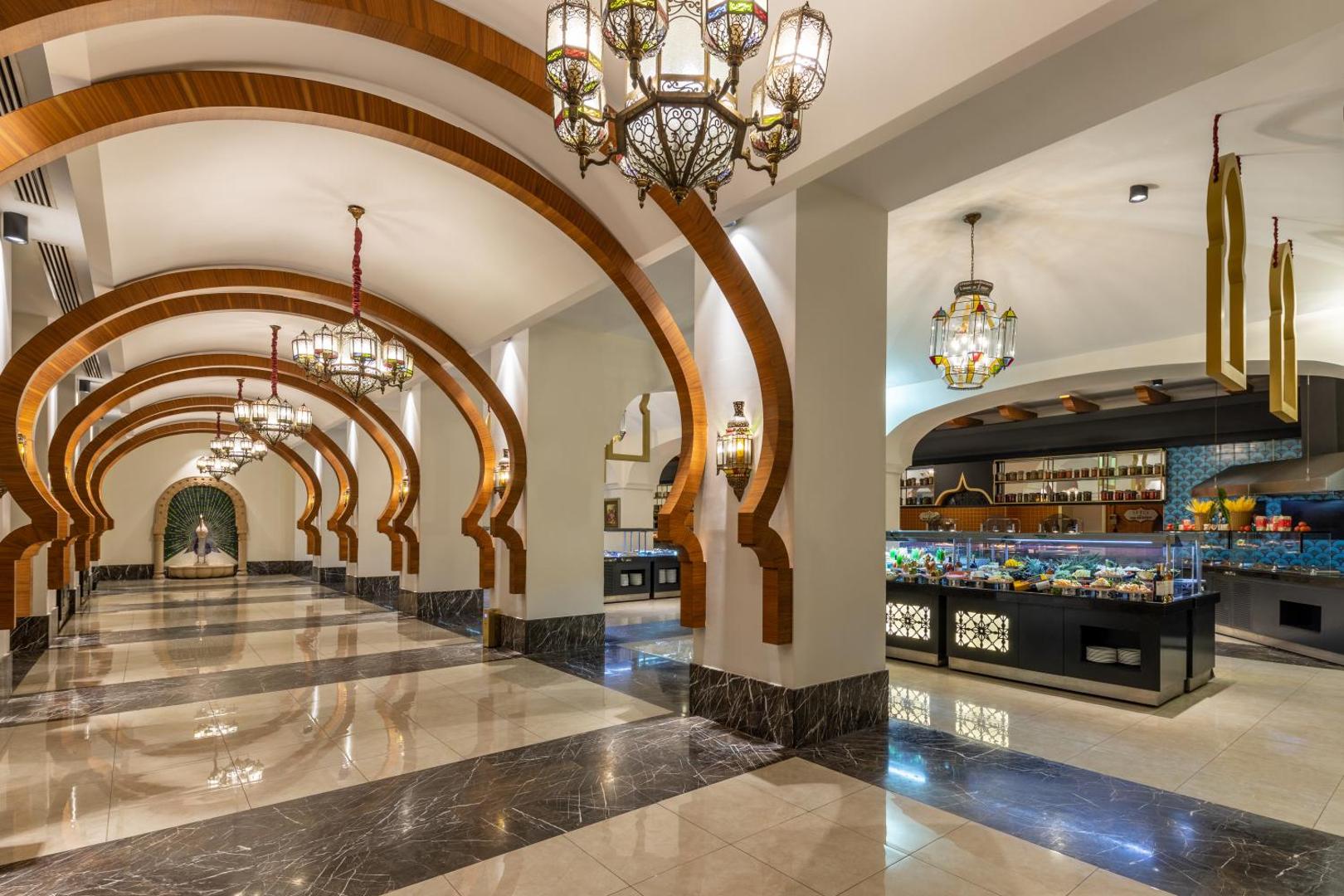 Spice Hotel & Spa galvenais restorāns ar bagātīgu bufetes zonu, marmora grīdām un dekoratīvām koka arkām Belekā