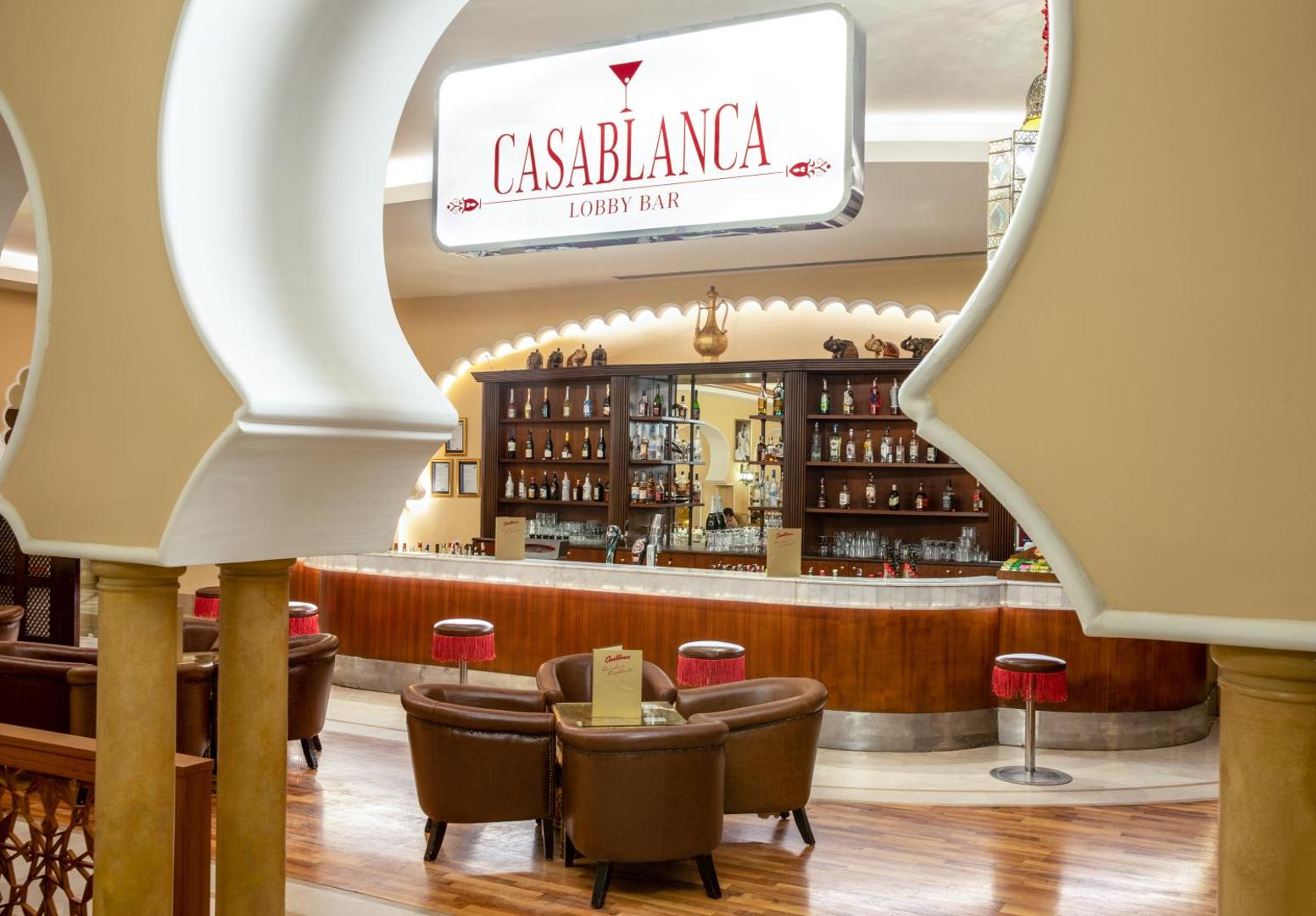 Spice Hotel & Spa Casablanca lobby bārs ar koka apdari, mīkstiem ādas krēsliem un plašu dzērienu izvēli viesnīcas foajē