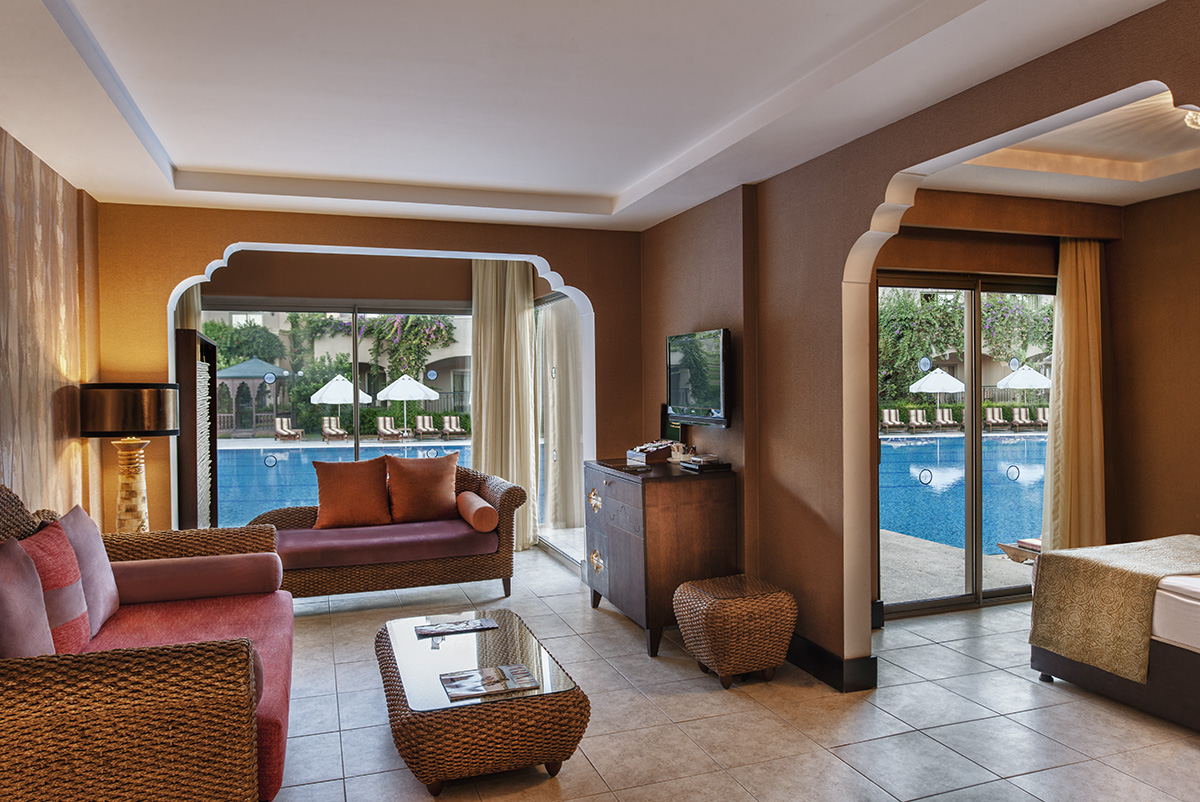 Spice Hotel & Spa numura viesistabas zona ar pīta koka mēbelēm un tiešu piekļuvi āra baseinam caur stikla durvīm