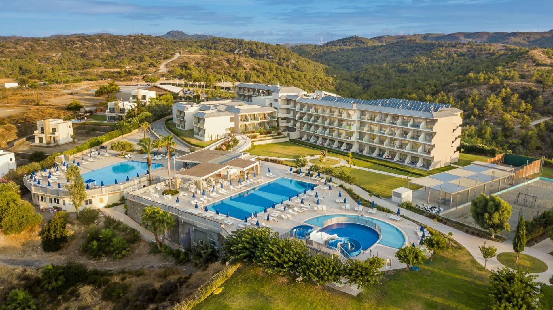 Princess Sun Hotel Rodas salā — panorāmas skats uz viesnīcas teritoriju, āra baseiniem un apkārtējiem kalniem saulainā dienā