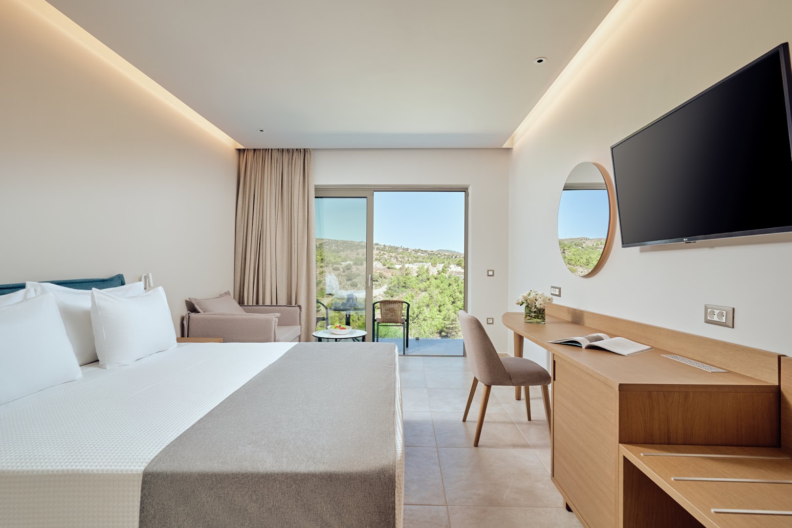 Princess Sun Hotel gaišs divvietīgs numurs Rodas salā ar balkonu, koka mēbelēm, sienas televizoru un skatu uz kalnaino piekrasti
