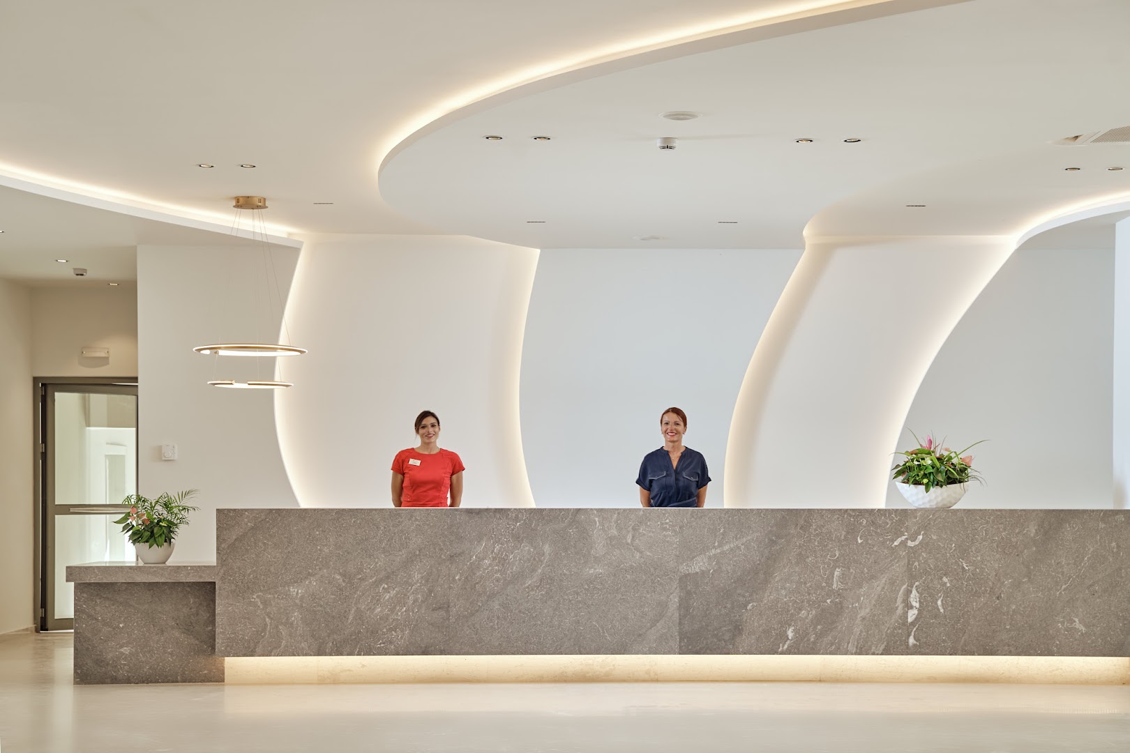 Princess Sun Hotel modernā recepcija Rodas salā ar akmens apdares leti, minimālistisku dizainu un viesmīlīgu personālu gaišā foajē