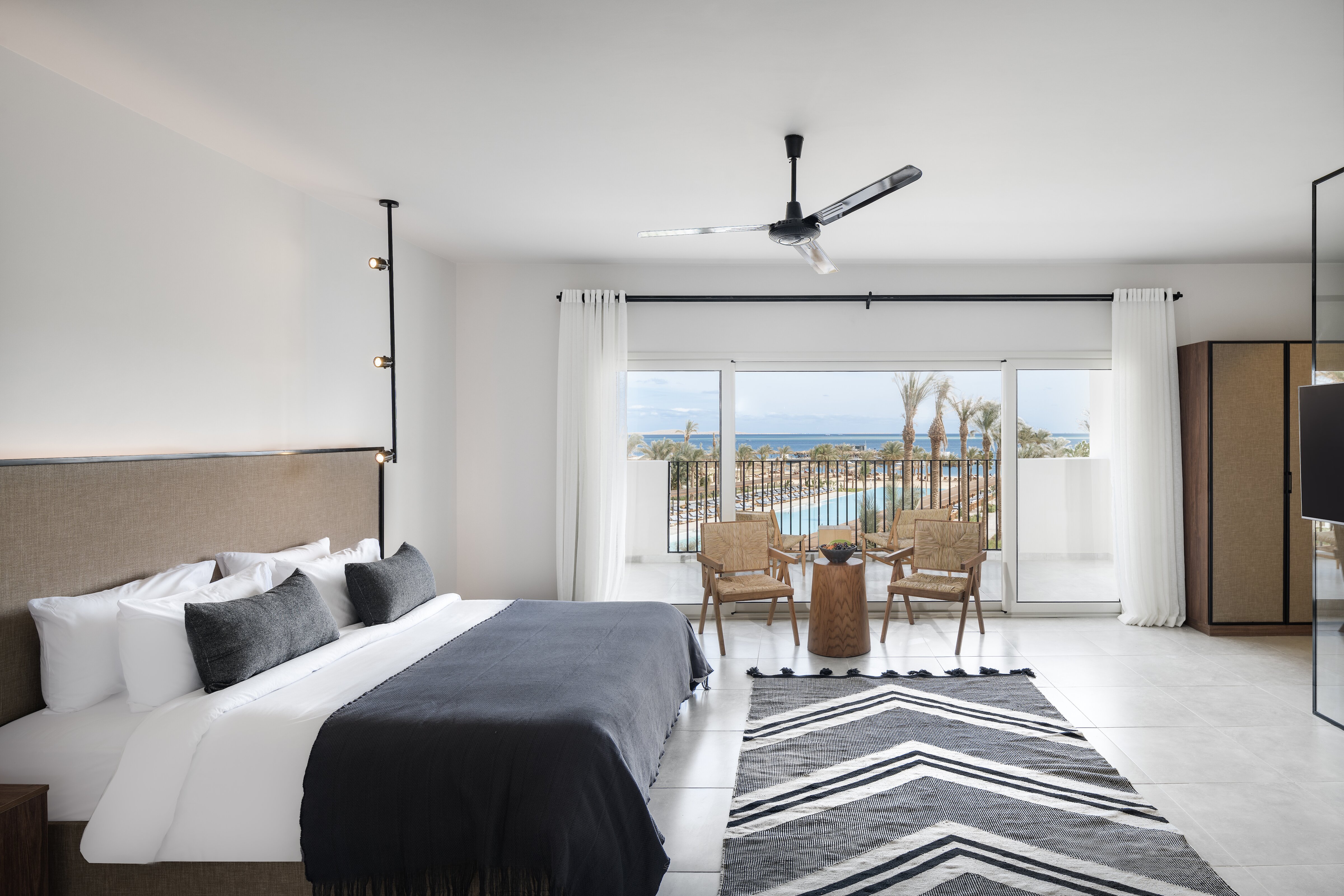 Serry Beach Resort plašs guļamistabas numurs ar balkonu, no kura paveras skats uz kūrorta baseiniem un Sarkano jūru Hurgadā.