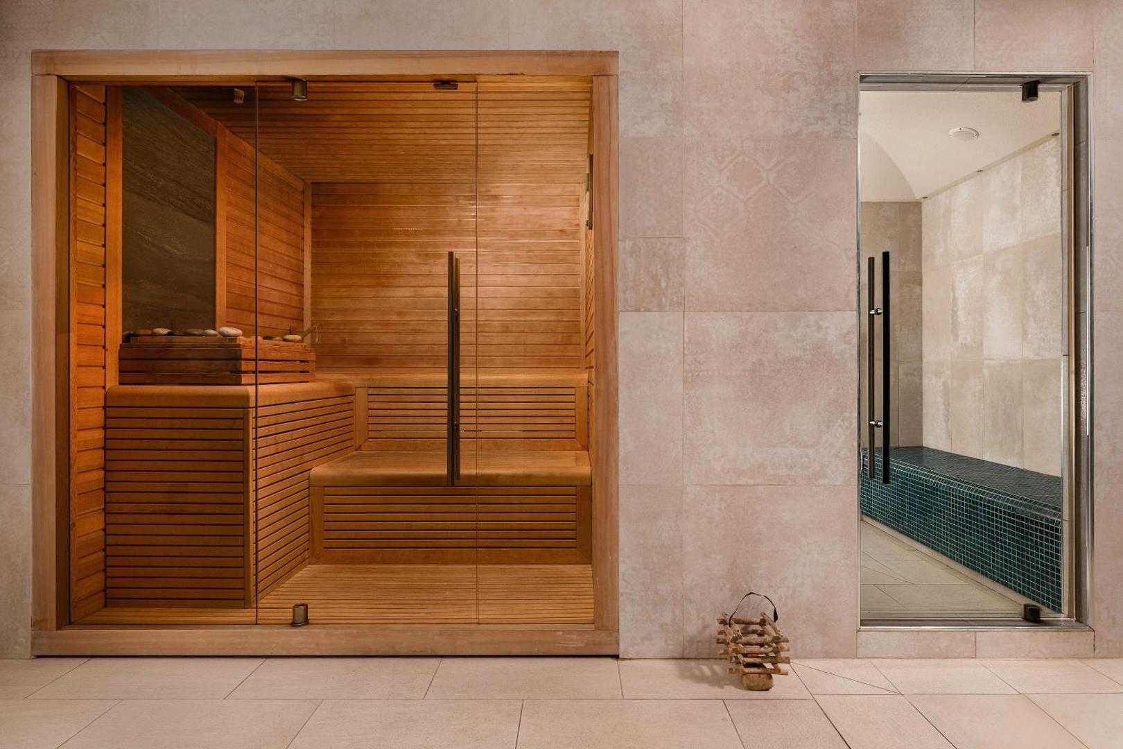 Electra Palace viesnīcas spa centrs ar koka saunu un tvaika pirti — moderna relaksācijas zona ar stikla durvīm un akmens apdari