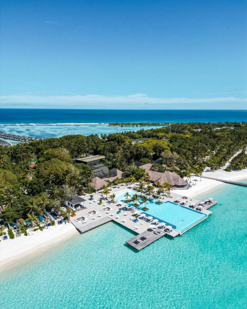 Villa Nautica Paradise Island kūrorta skats no putna lidojuma uz galveno baseinu, balto smilšu pludmali un tirkīzzilo lagūnu Maldīvu salās