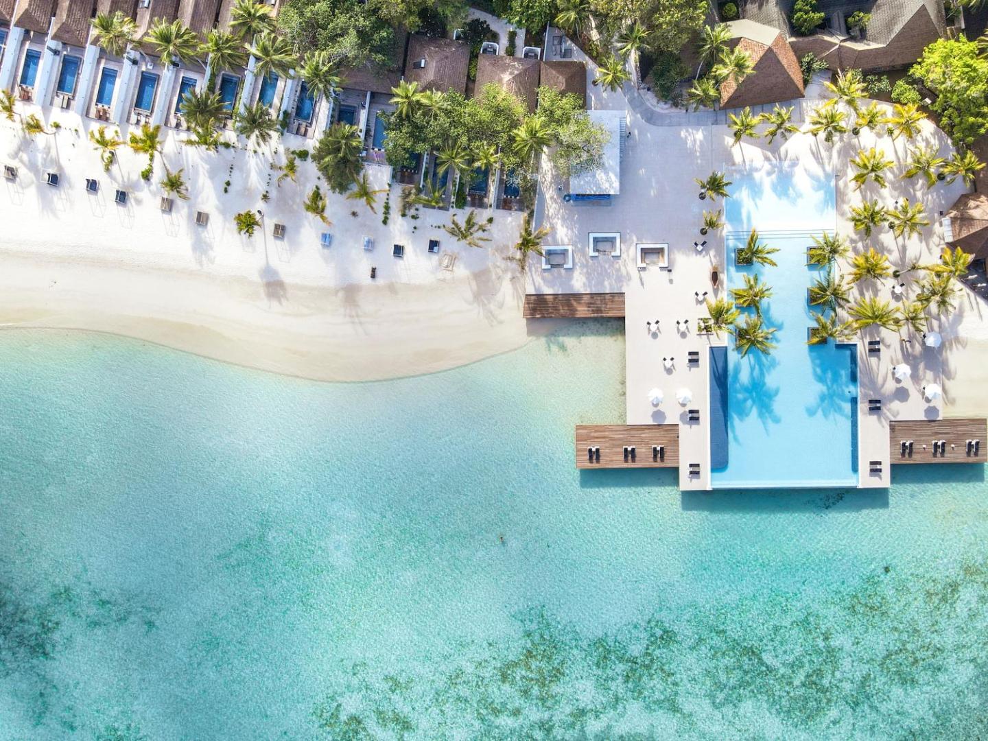 Villa Nautica Paradise Island aerofoto ar pludmali, bungalo numuriem un baseinu pie kristāldzidra okeāna krasta