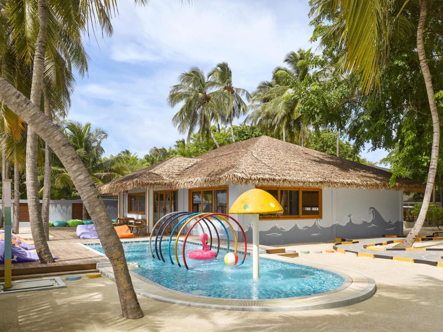 Villa Nautica Paradise Island bērnu kluba āra zona ar seklu baseinu, ūdens strūklakām un rotaļu elementiem palmu ieskautā teritorijā