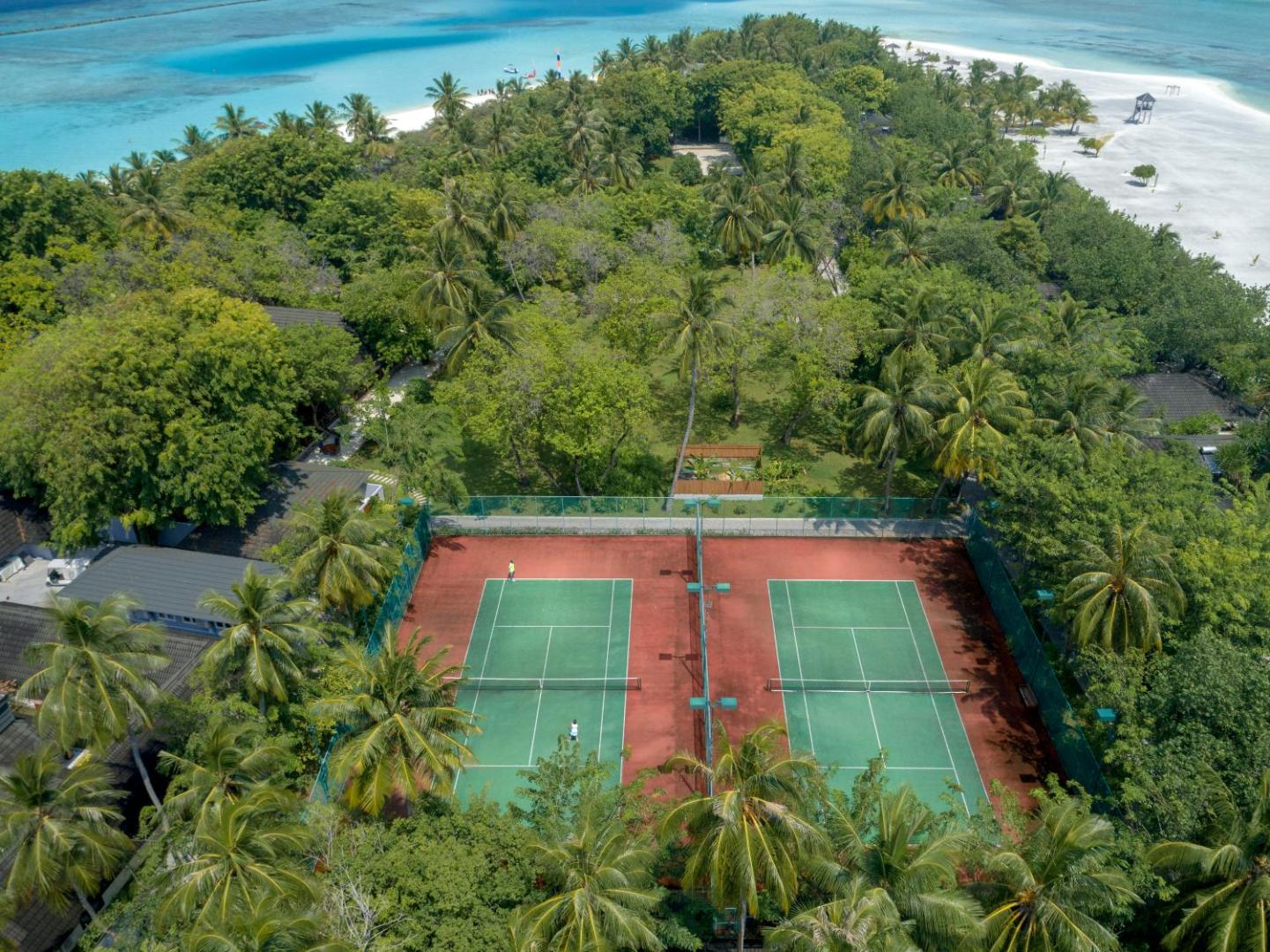 Villa Nautica Paradise Island tenisa korti no putna lidojuma, ko ieskauj blīvs palmu mežs un tirkīzzils okeāns fonā