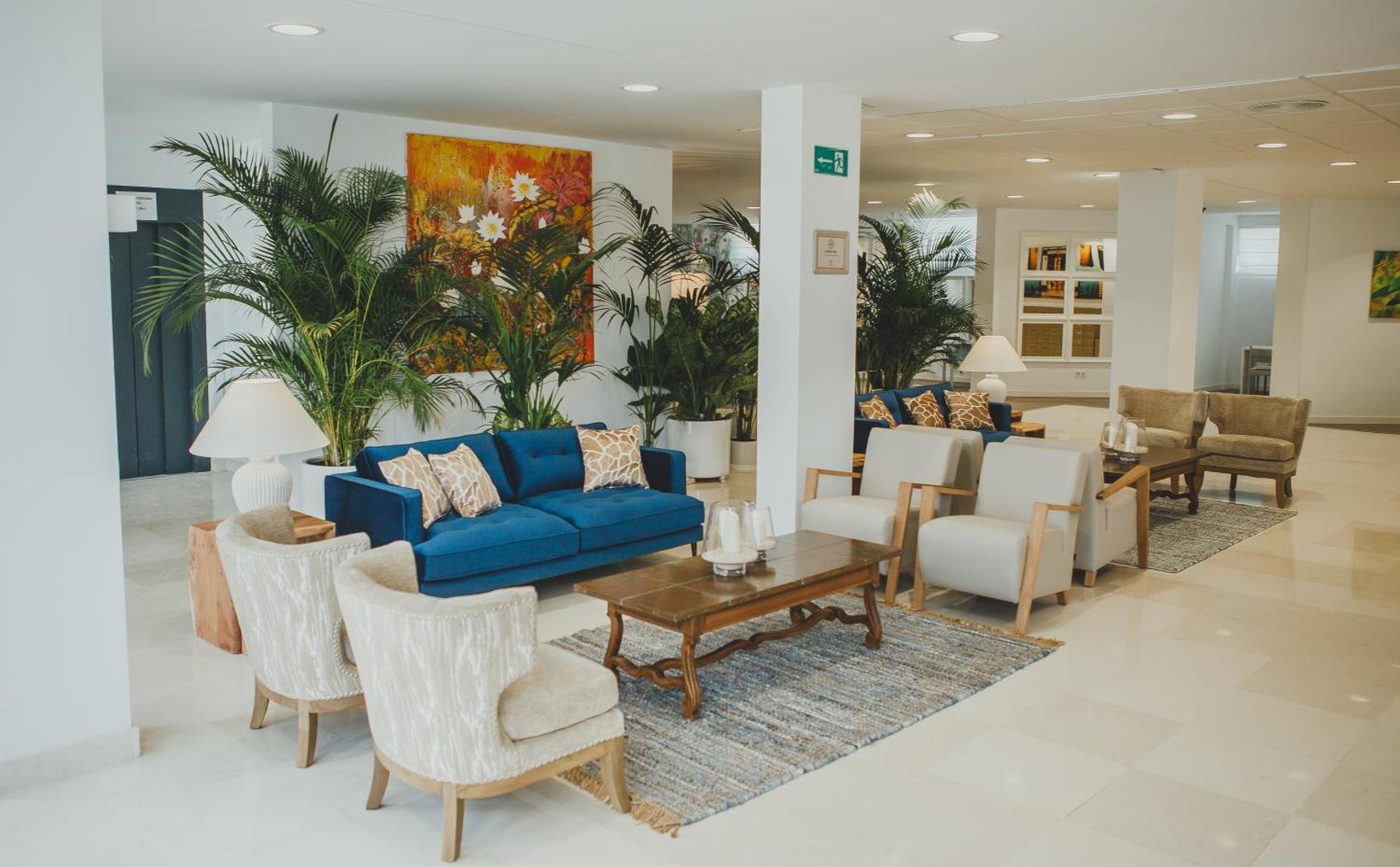 Hotel Alay lobby atpūtas zona ar ziliem dīvāniem, krēsliem un telpaugiem — plašs un moderns viesnīcas vestibils Benalmadenā