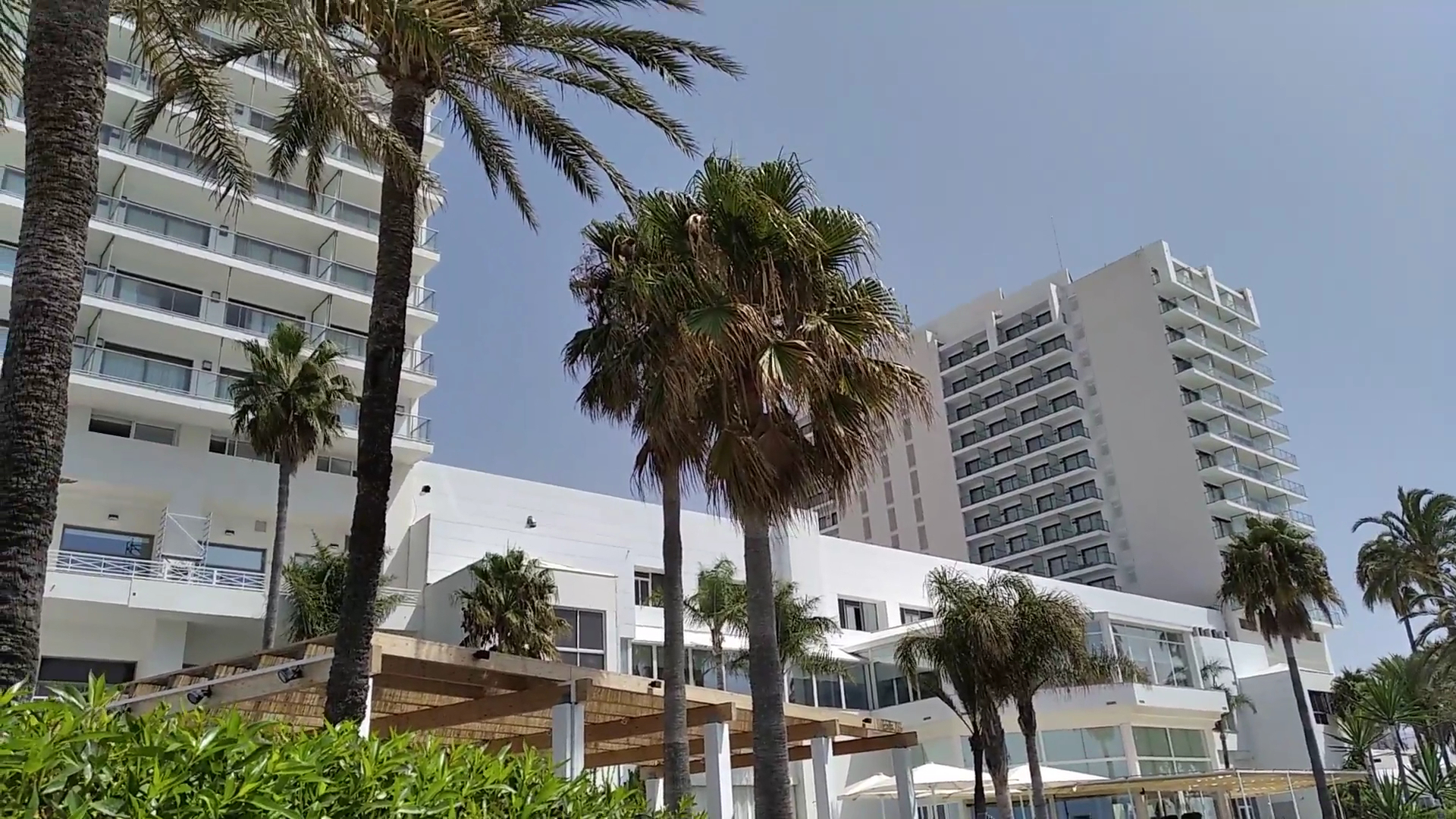 Estival Torrequebrada viesnīcas modernā fasāde ar balkoniem un augstām palmām priekšplānā saulainā dienā Benalmadenā