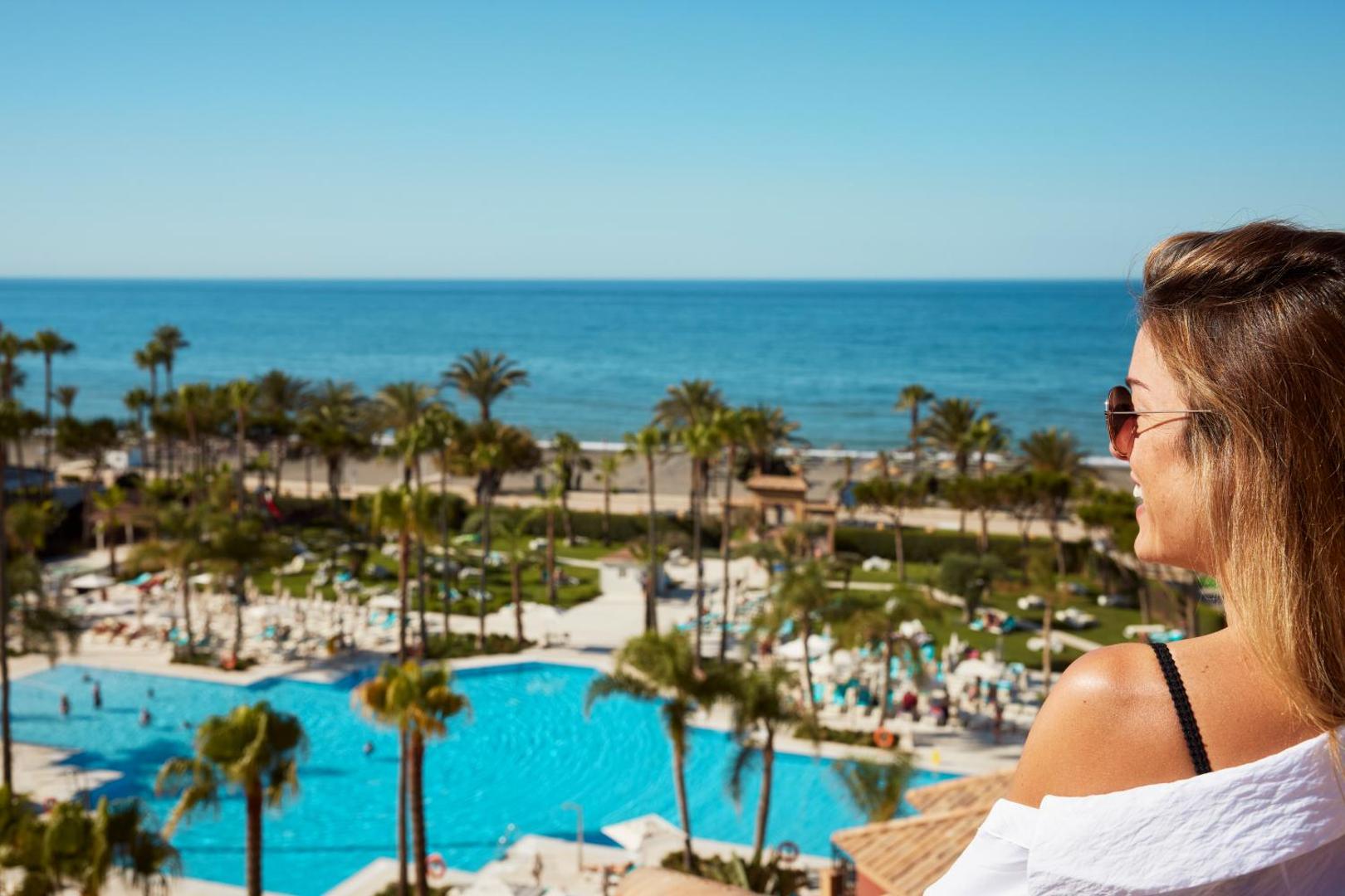 Skats no augšas uz Iberostar Malaga Playa baseinu kompleksu, palmām un smilšu pludmali pie Vidusjūras.