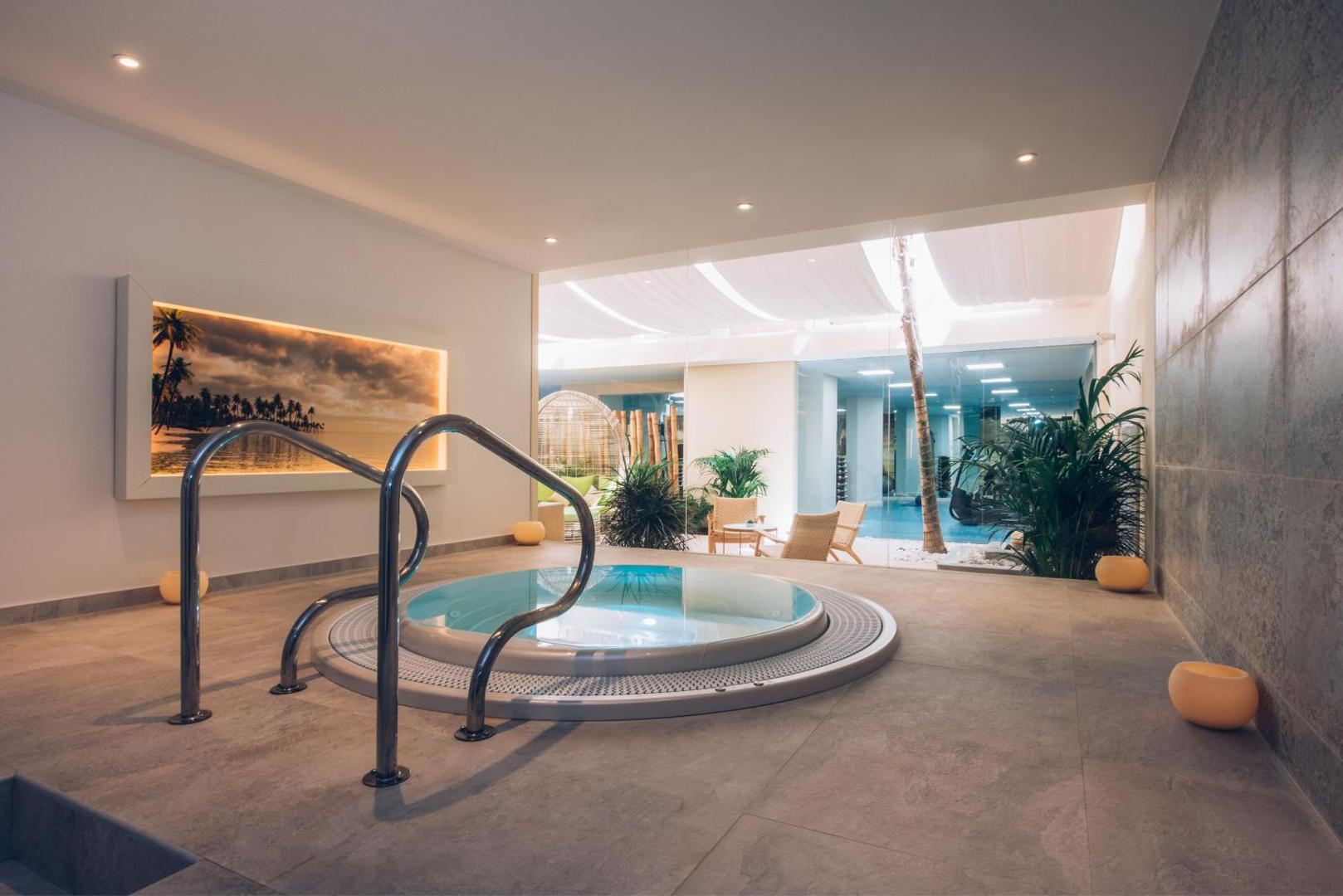 Iberostar Marbella Coral Beach spa zonas iekštelpu džakuzi baseins ar metāla margām un siltu apgaismojumu relaksācijai