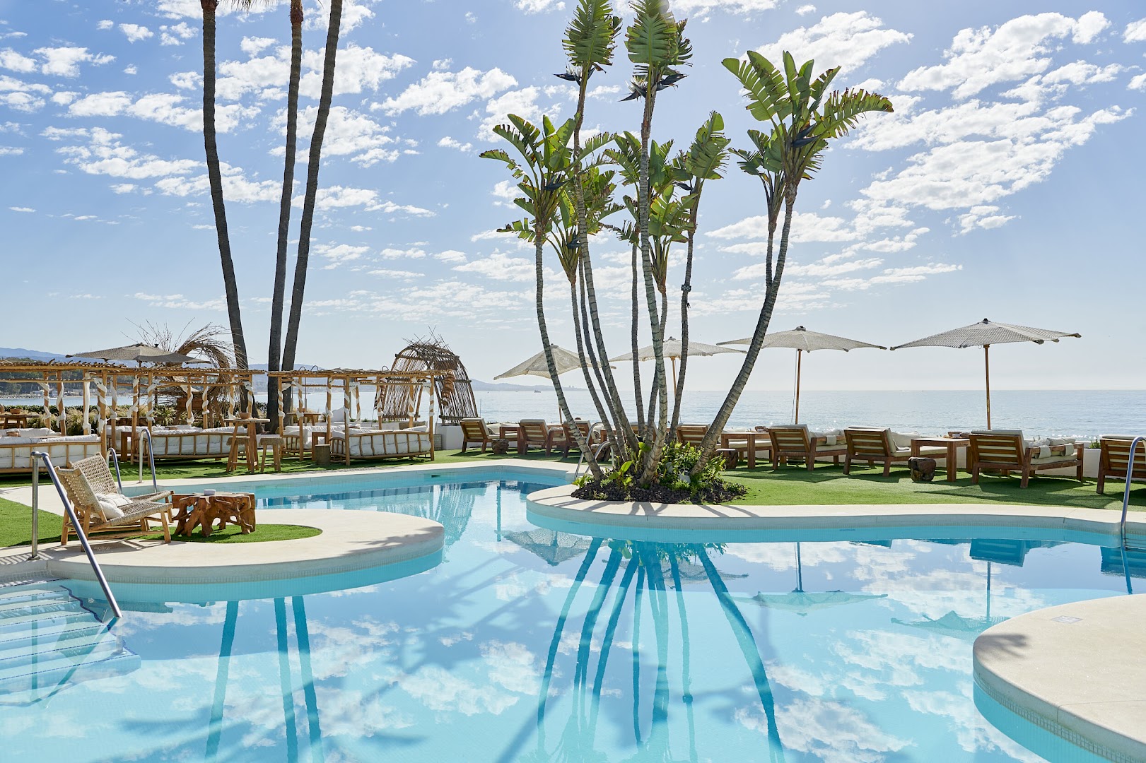 Skats no Iberostar Marbella Coral Beach baseina malas uz Vidusjūru ar saulessargiem un ērtām gultām pludmales zonā