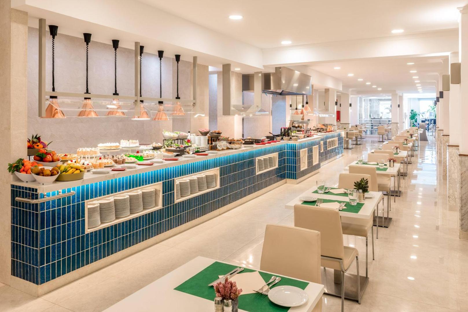 Las Arenas affiliated by Melia restorāna bufetes zona ar plašu ēdienu izvēli, augļiem un modernu interjeru zilā krāsā