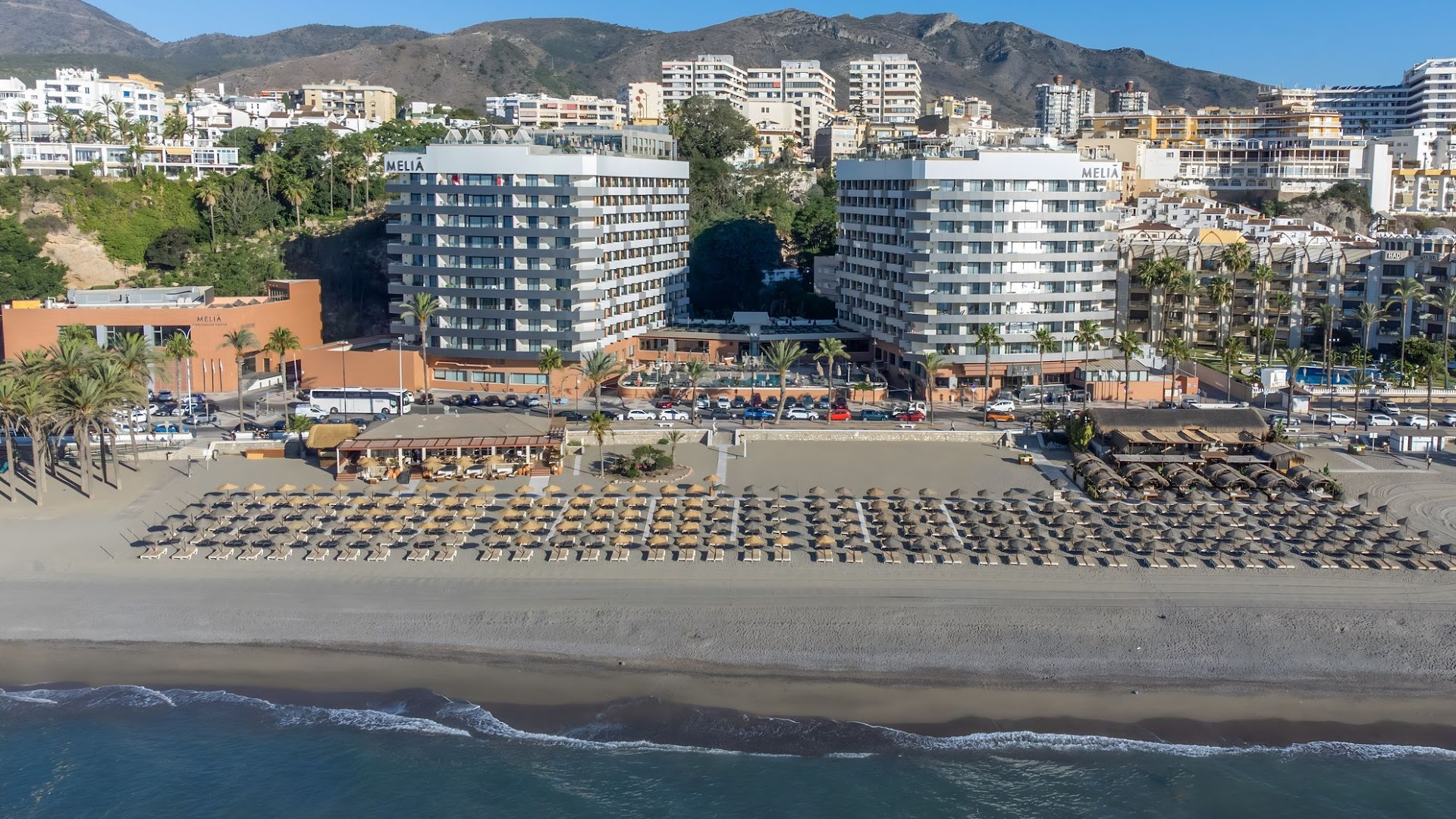 Melia Costa del Sol viesnīcas ēkas no putna lidojuma Torremolinosā — plaša smilšu pludmale ar saulessargiem un Vidusjūras krasta līnija