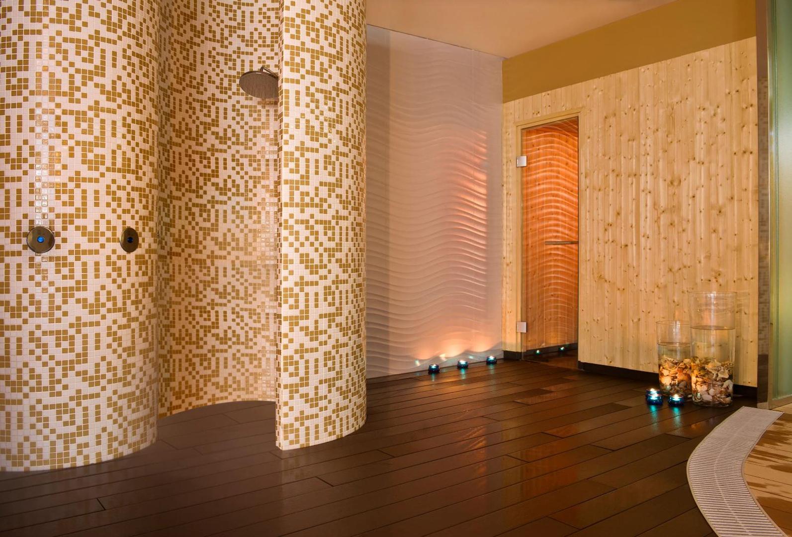 Melia Costa del Sol spa centra dušas zona ar mozaīkas flīzēm un ieeju koka saunā relaksācijai