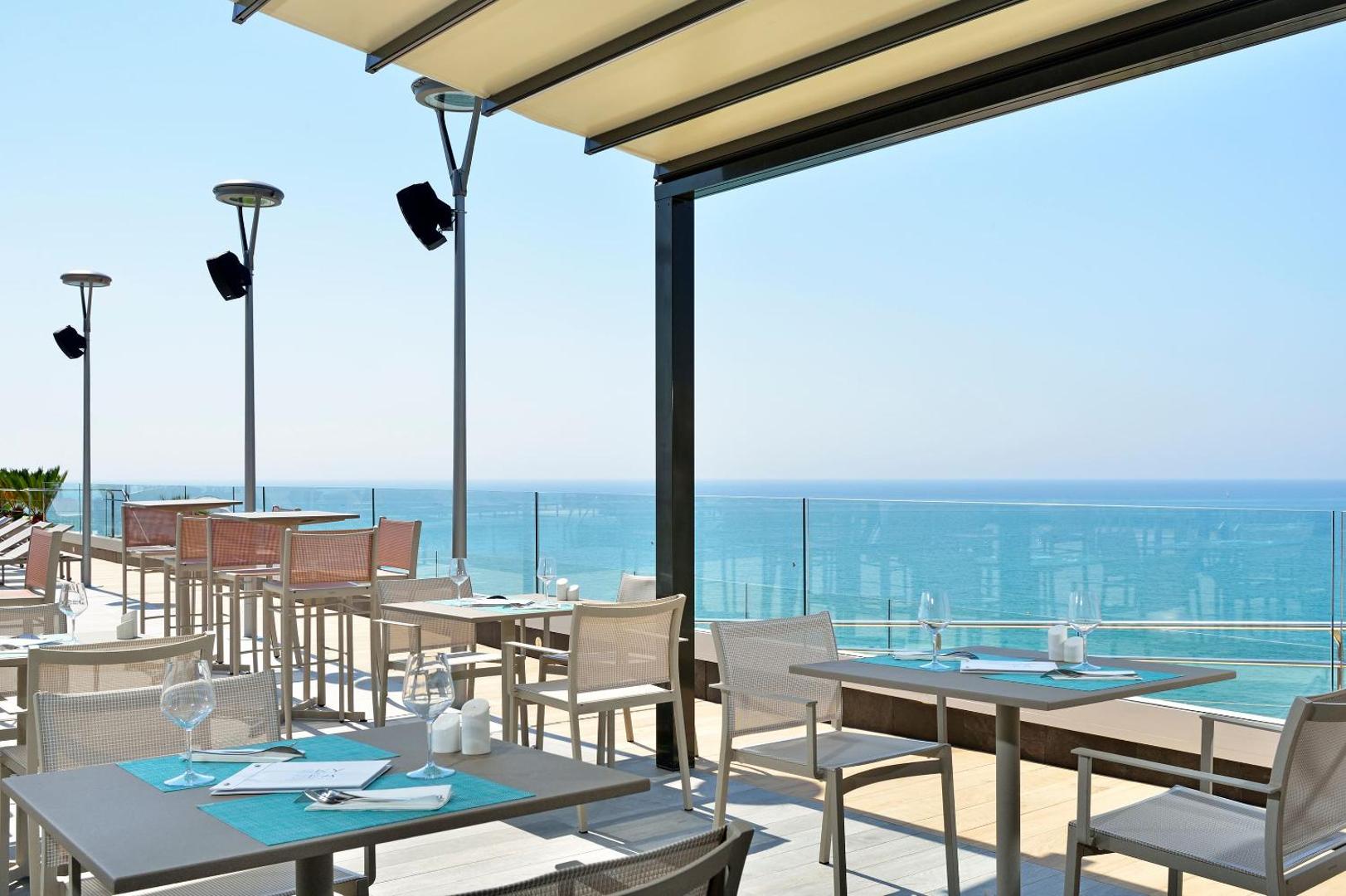 Melia Costa del Sol āra terases restorāns ar skatu uz Vidusjūru Torremolinosā — eleganti klāti galdi pie stikla margām