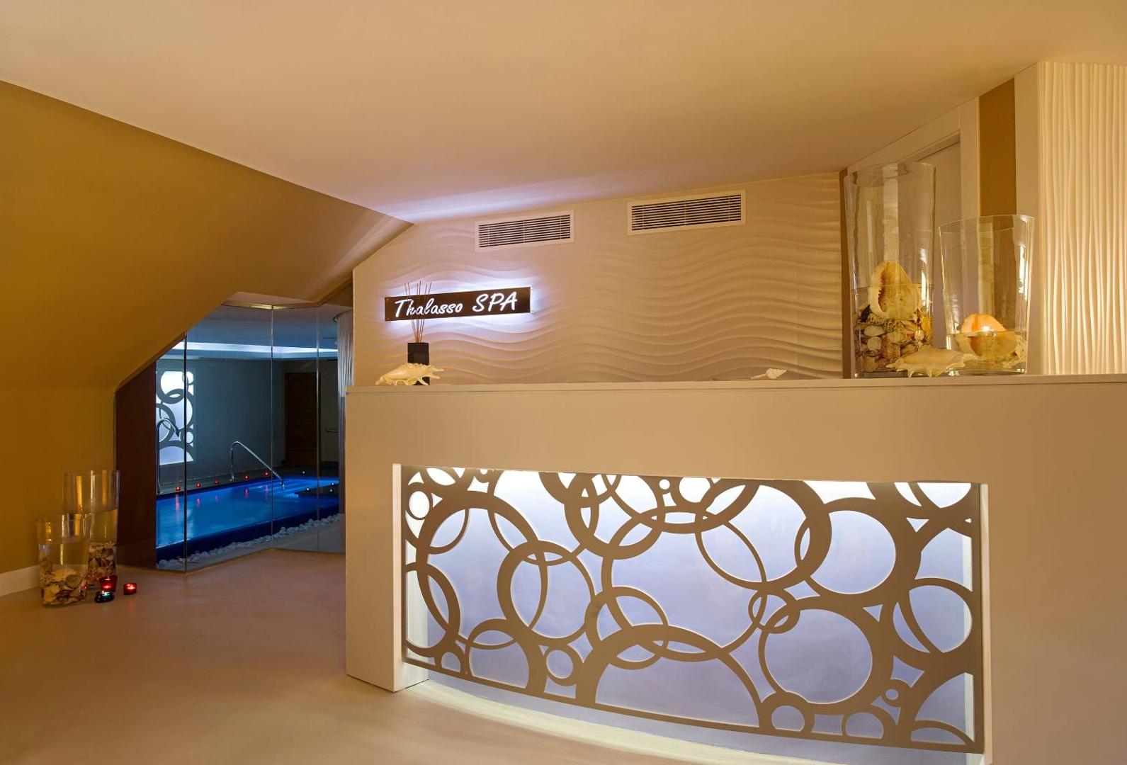 Melia Costa del Sol Thalasso SPA recepcijas zona ar dekoratīvu apgaismojumu un skatu uz iekštelpu baseinu
