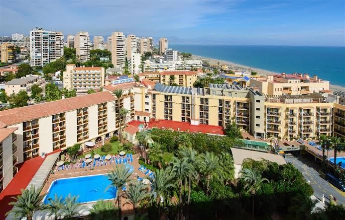 Sol Don Pedro viesnīcas panorāmas skats Torremolinosā ar āra baseinu, palmu dārzu un Vidusjūras piekrasti fonā Spānijā