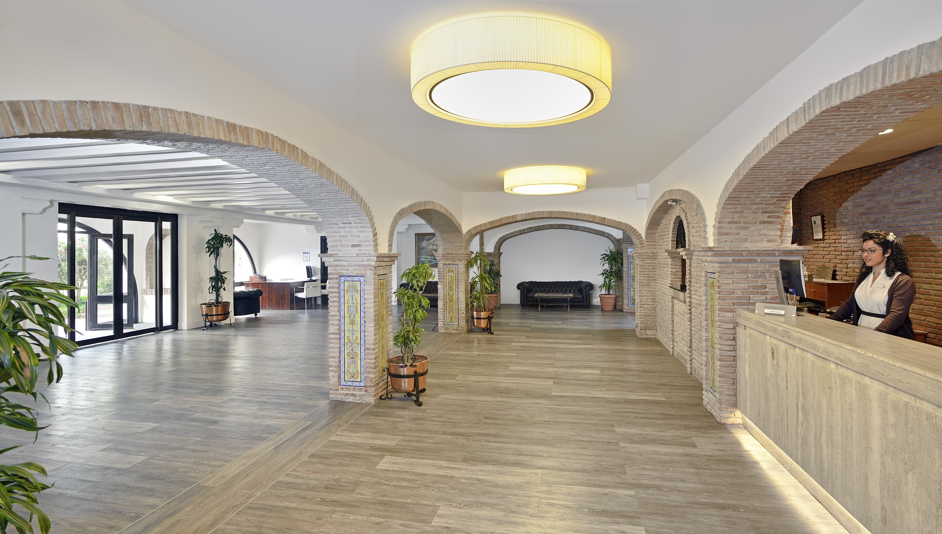 Sol Don Pedro viesnīcas recepcijas zona ar tradicionālām ķieģeļu arkām un koka grīdu Andalūzijas stilā