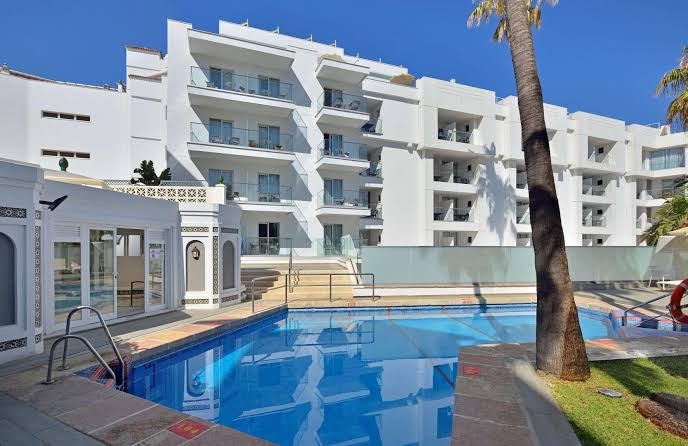 Sol Don Marco viesnīcas baseina zona ar skatu uz modernu balto ēku un balkoniem Torremolinosas kūrortā