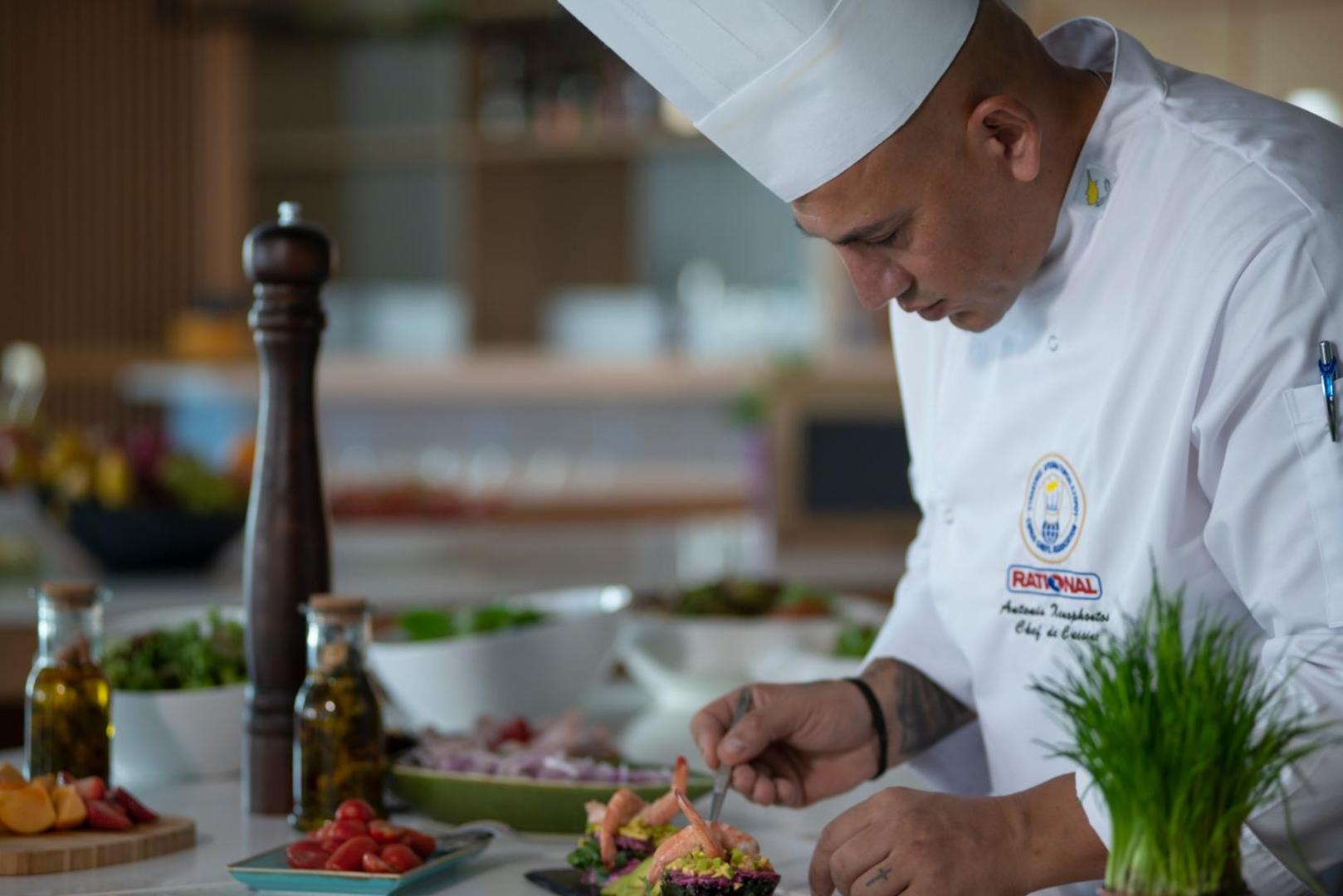 At Herbal Boutique Hotel & Spa šefpavārs gatavo uzkodas ar garnelēm viesnīcas restorāna virtuvē — augstas klases serviss un kvalitāte