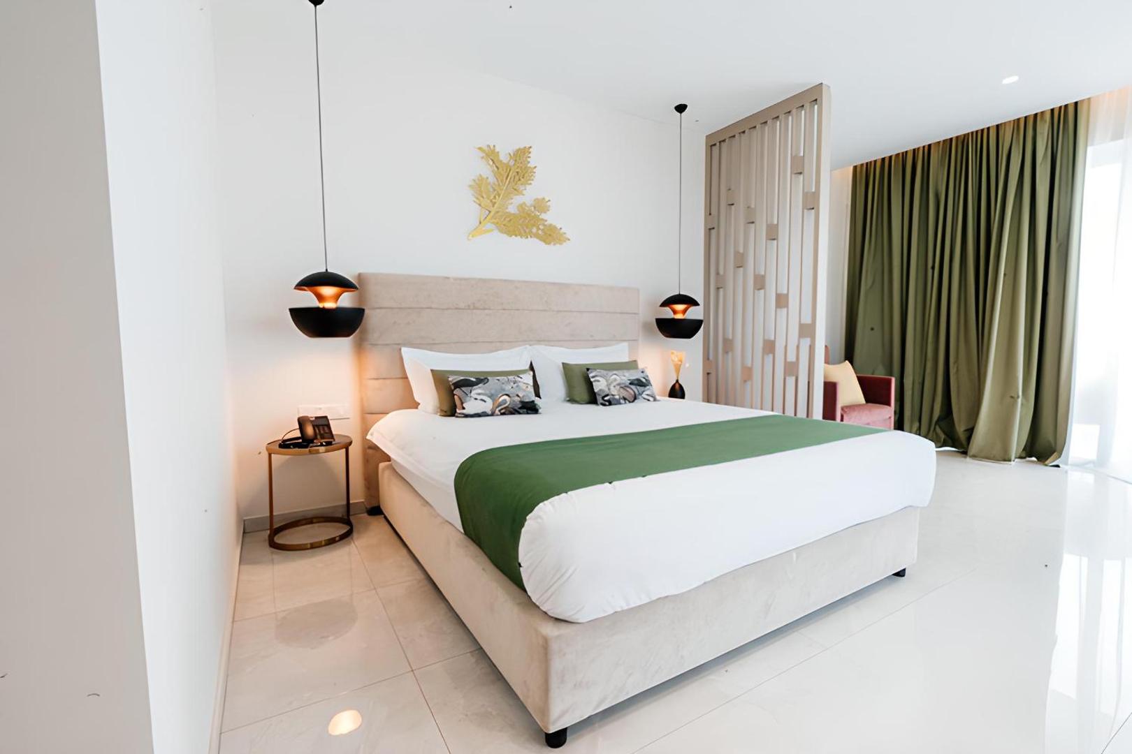 At Herbal Boutique Hotel & Spa moderns numurs ar lielu gultu, zaļiem akcentiem un dizaina gaismekļiem Protarasā, Kiprā