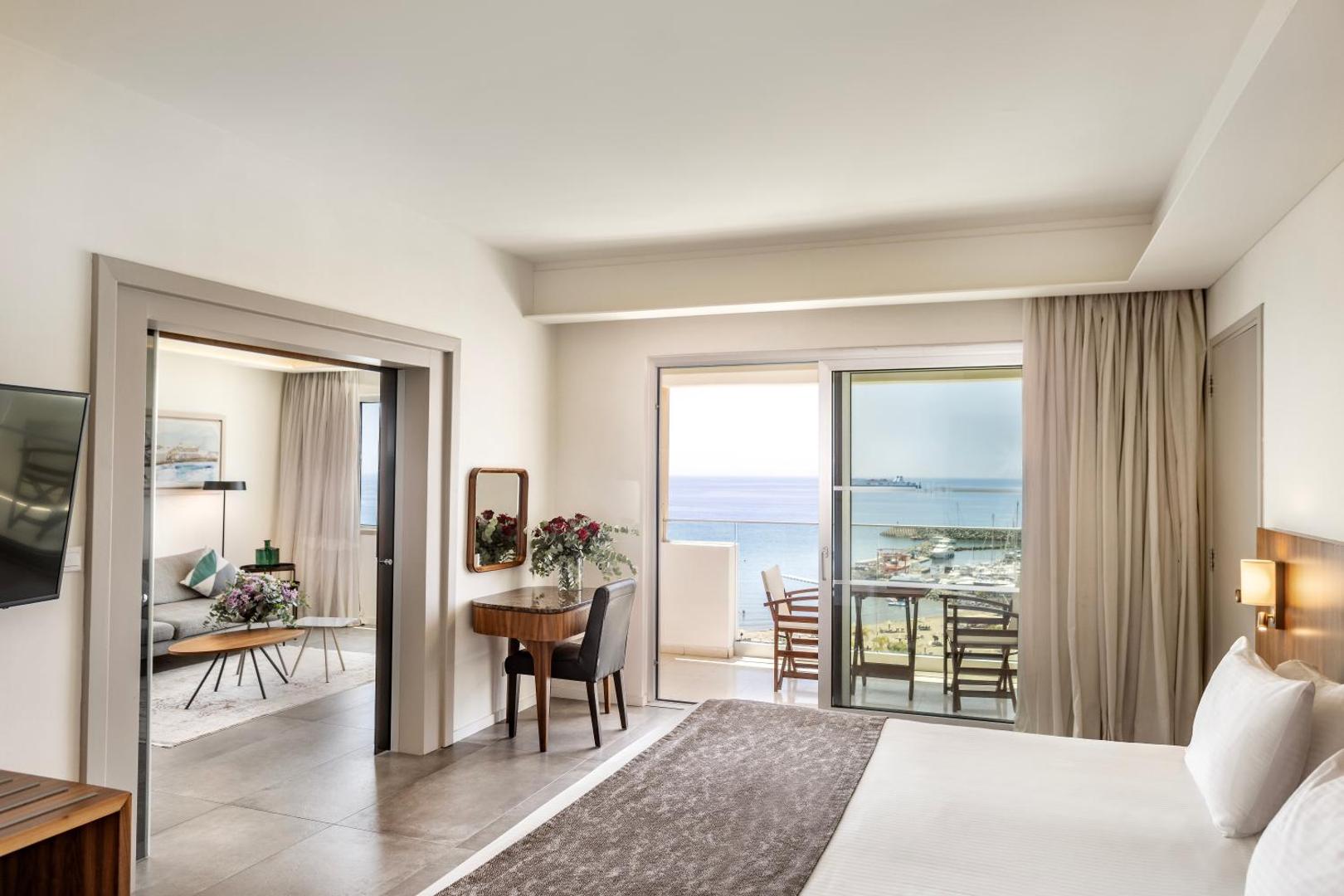 St. Raphael Resort luksusa numurs ar atsevišķu viesistabas zonu un balkonu, no kura paveras skats uz jahtu piestātni