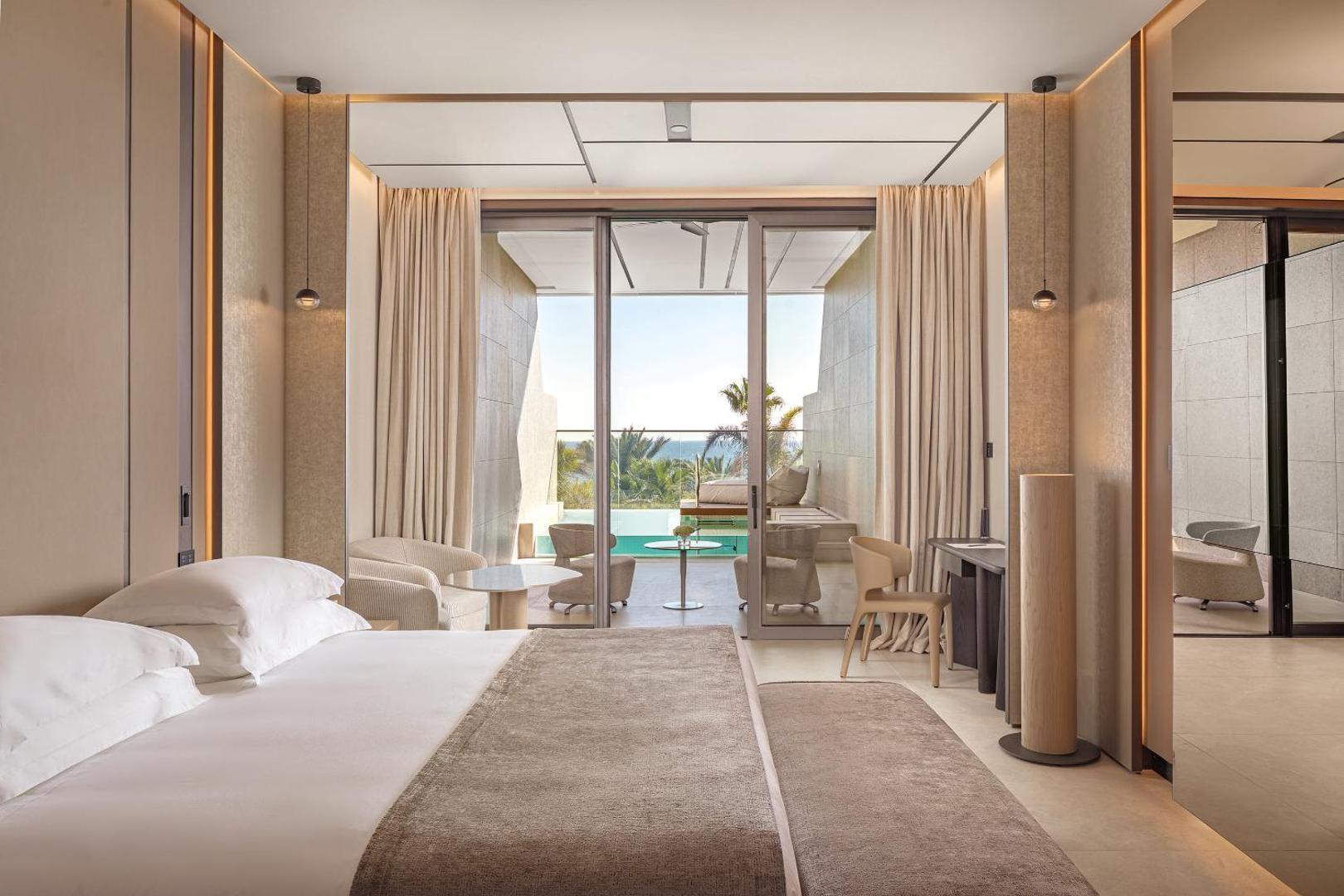 Amathus Beach viesnīcas luksusa numurs ar skatu uz jūru un privātu terasi, kurā redzams neliels baseins un atpūtas zona.