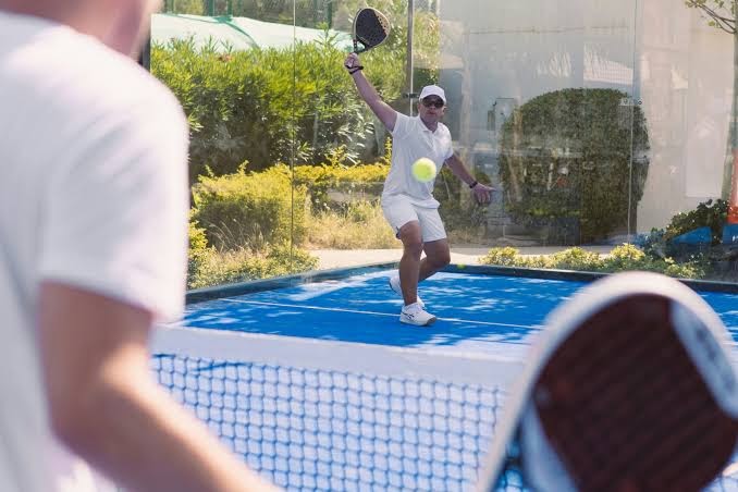 Viesi spēlē padelu Parklane, A Luxury Collection Resort & Spa zilā āra laukumā Limasolā, Kiprā — aktīva atpūta kūrorta teritorijā