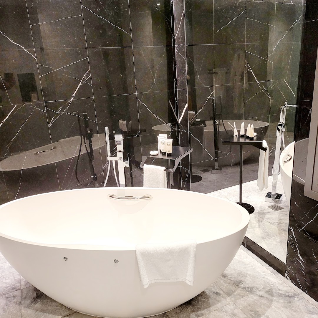 Parklane, A Luxury Collection Resort & Spa vannasistaba ar brīvstāvošu vannu un tumša marmora sienām — luksusa klases dizains