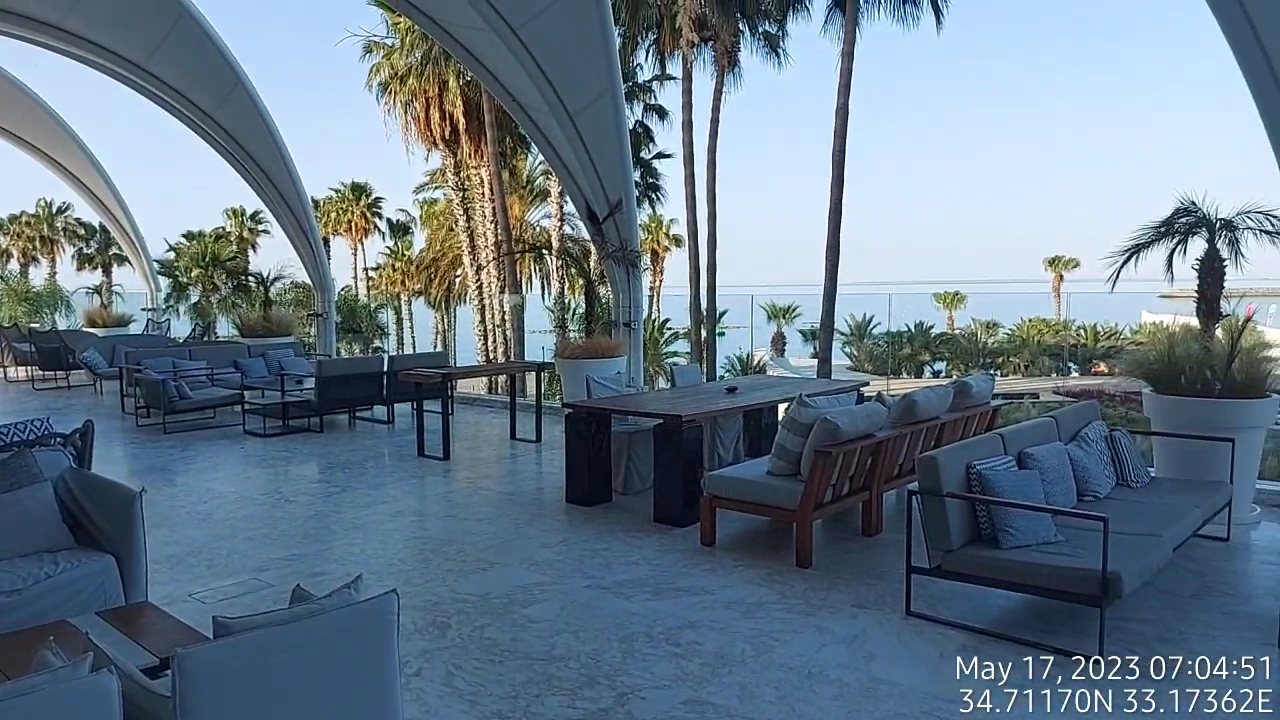 Parklane Resort & Spa atpūtas zona ar dīvāniem un skatu uz Vidusjūru Limasolā — moderna terase ar palmām un stikla margām