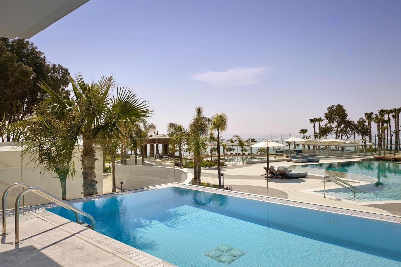 Parklane Resort & Spa numura terases baseins ar stikla nožogojumu un skatu uz kūrorta teritoriju un palmām