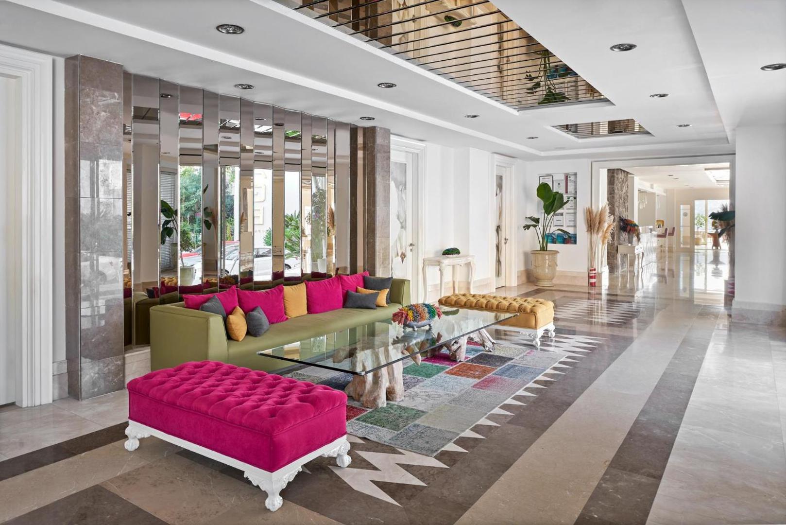 Prive Hotel Bodrum lobby zona ar modernu dizainu, košiem dīvāniem, spoguļu sienu un stikla galdu