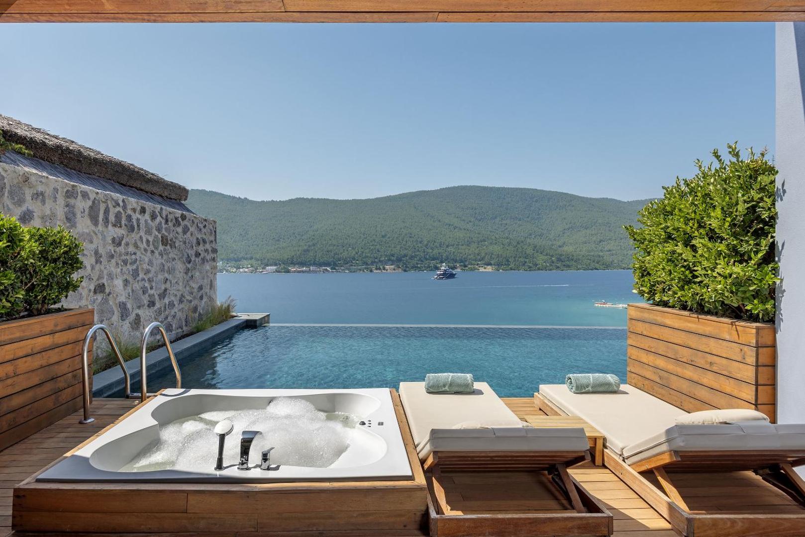 Privātā terase ar džakuzi un bezgalības baseinu Titanic Luxury Collection Bodrum viesnīcā ar skatu uz jūru un kalniem