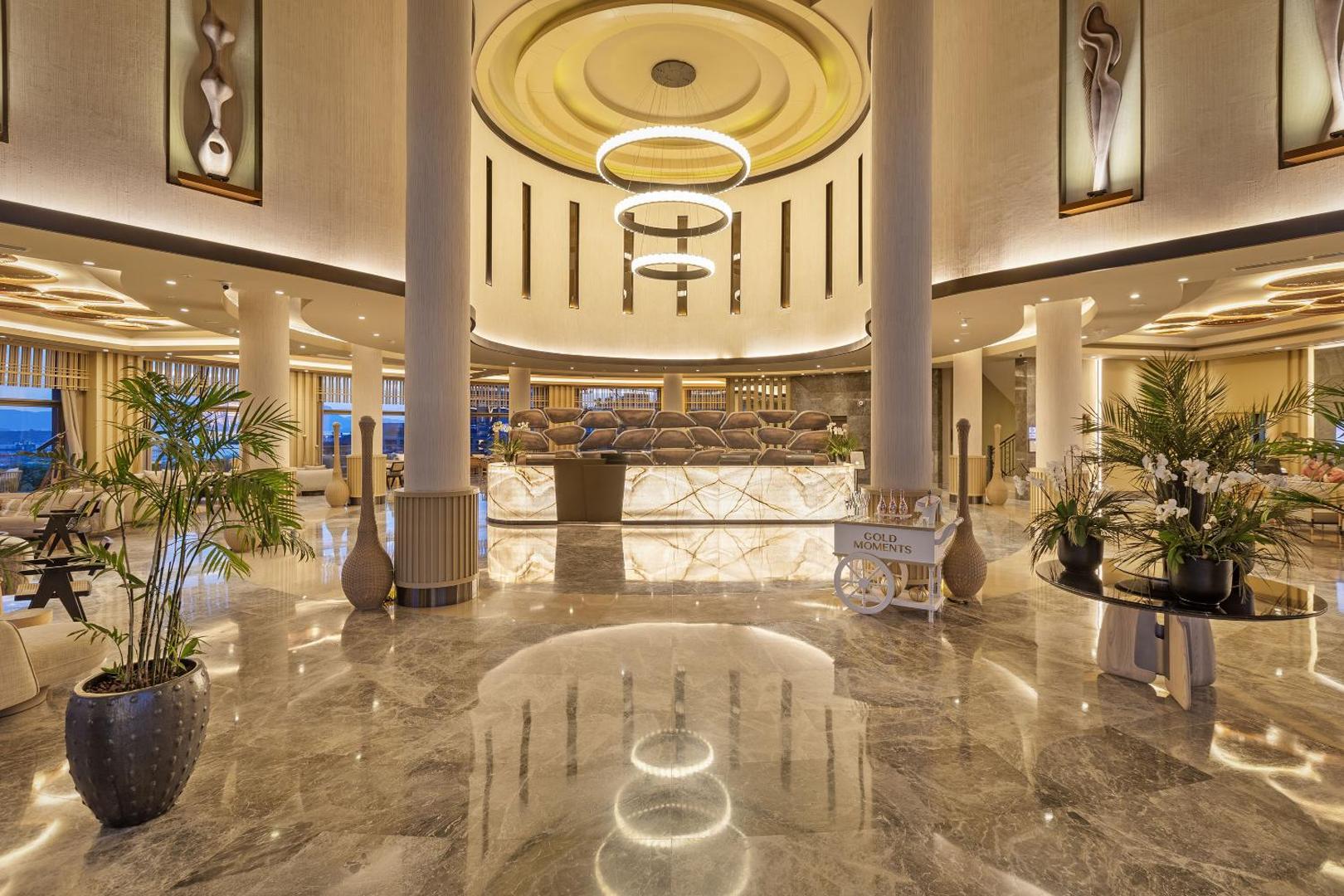 Titanic Luxury Collection Bodrum viesnīcas plašais un greznais lobby vestibils ar marmora grīdām un iespaidīgu dizaina apgaismojumu