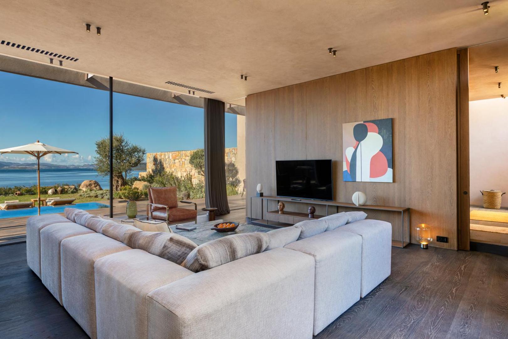 Lujo Hotel Bodrum villas viesistaba ar panorāmas skatu uz Egejas jūru, privāto baseinu un dārzu saulainā dienā