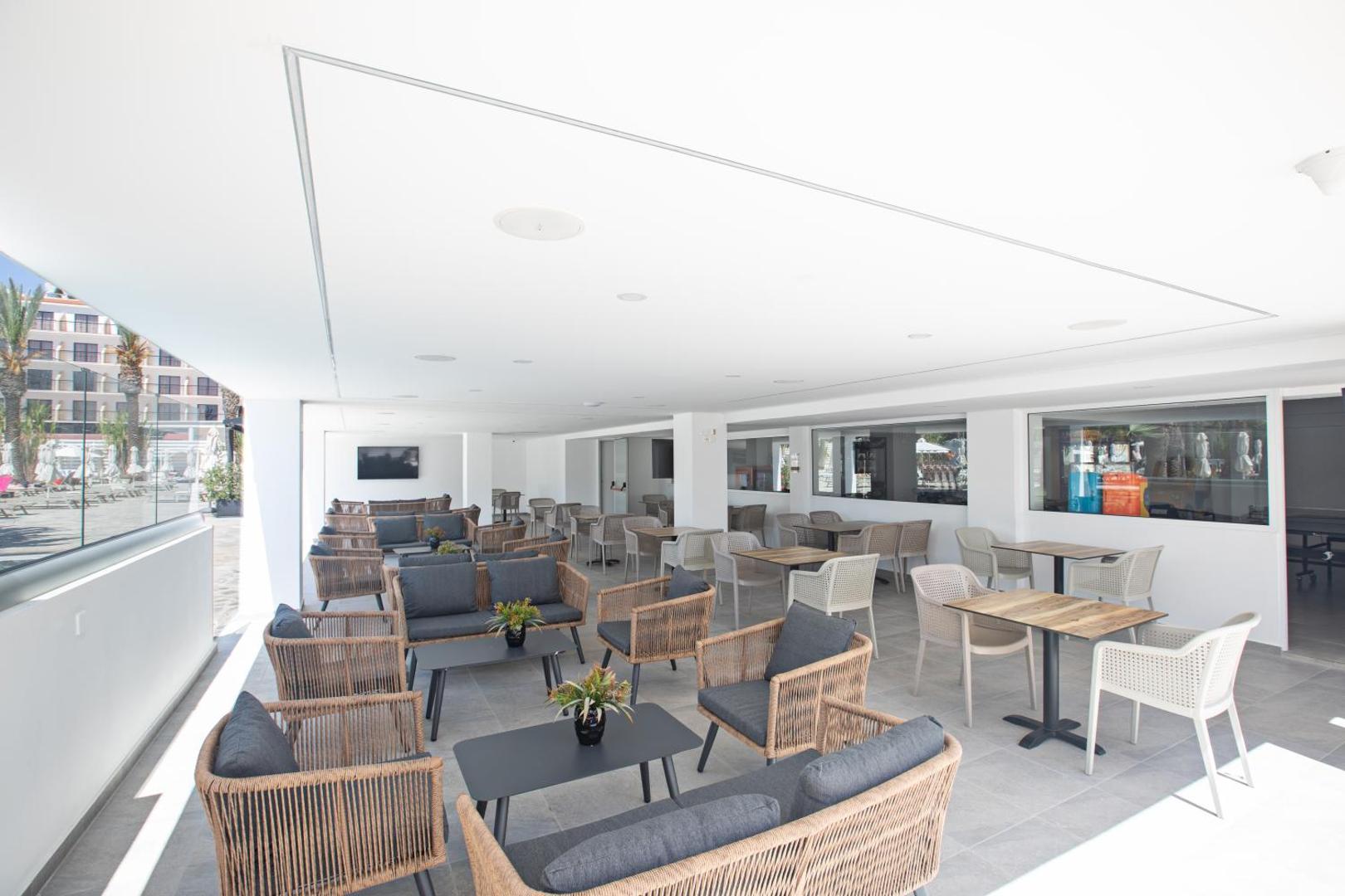 Bohemian Gardens Hotel gaiša āra terase ar modernām mēbelēm un atpūtas zonu pie baseina Protarasā