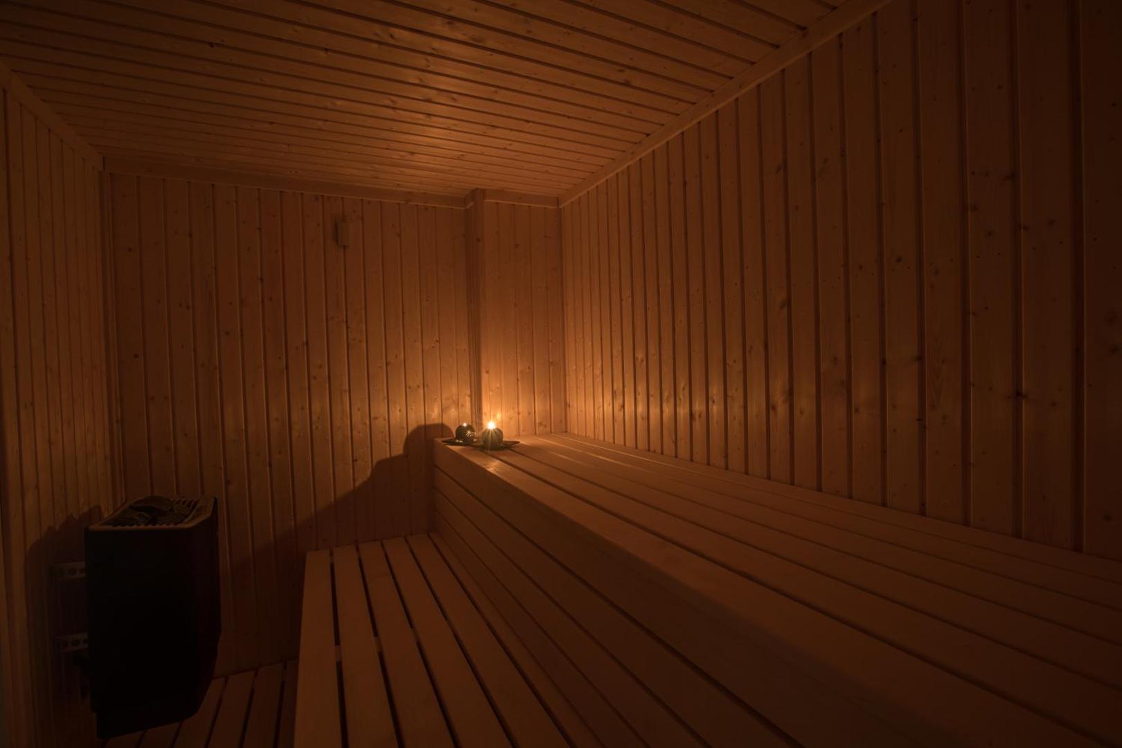 Bohemian Gardens Hotel spa zonas koka sauna ar siltu apgaismojumu un svecēm — relaksējoša atpūtas vieta viesiem Kiprā