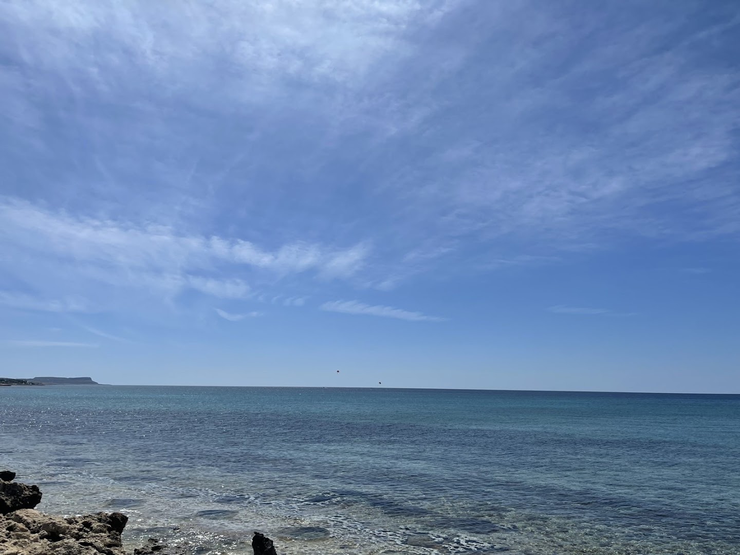 Plašs skats uz jūru un debesīm no Adams Beach krasta līnijas — mierīgs ūdens un gaiši zilas debesis