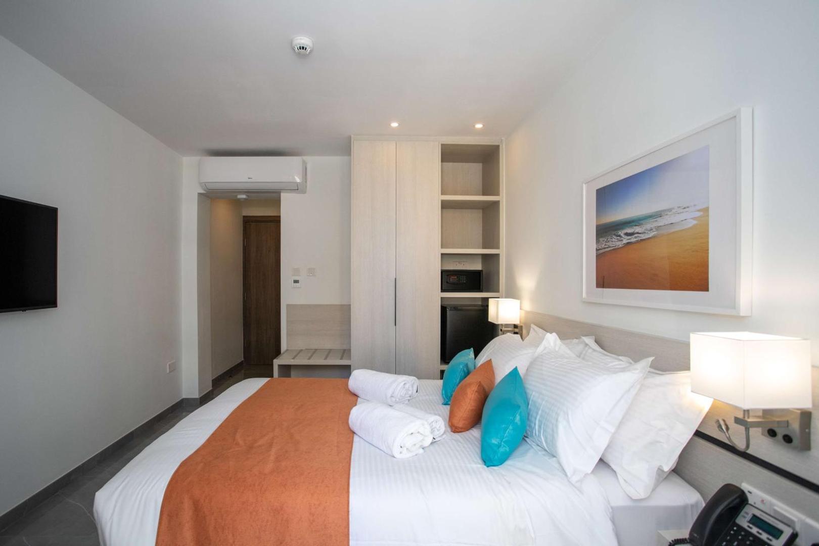 Best Western Plus Larco Hotel numura interjers ar skapi, seifu, mini ledusskapi un ērtu gultu ar dekoratīviem spilveniem.
