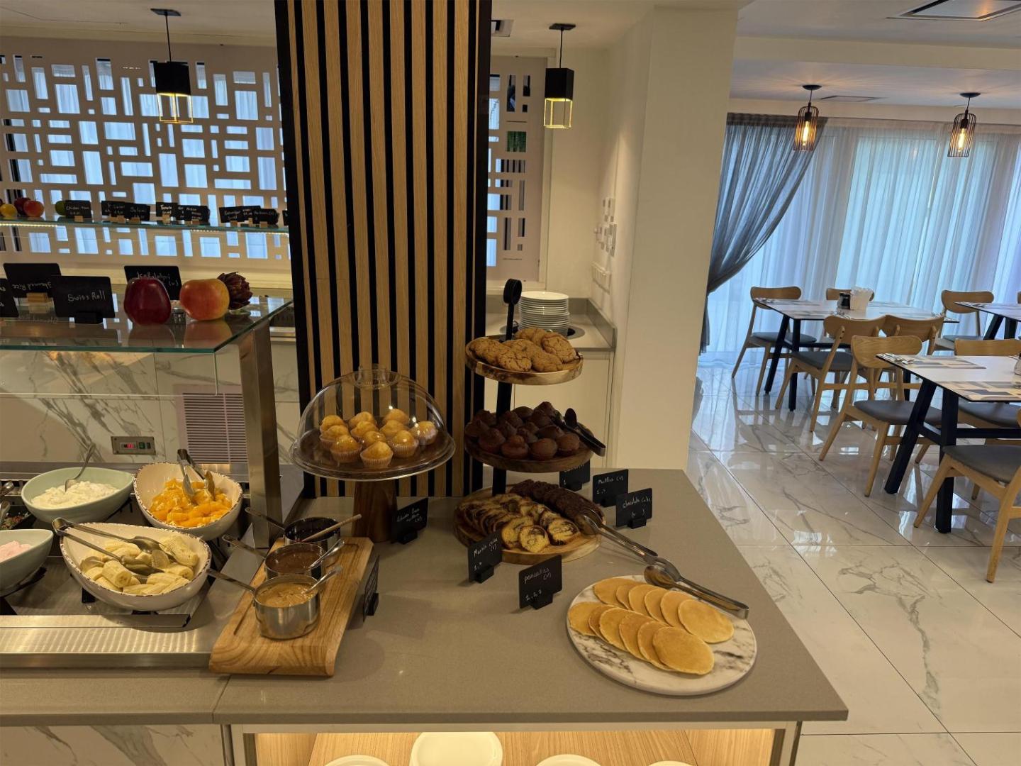 Best Western Plus Larco Hotel konditorejas un augļu stends — smalkmaizītes, pankūkas un svaigi augļi viesnīcas restorāna gaišajā interjerā