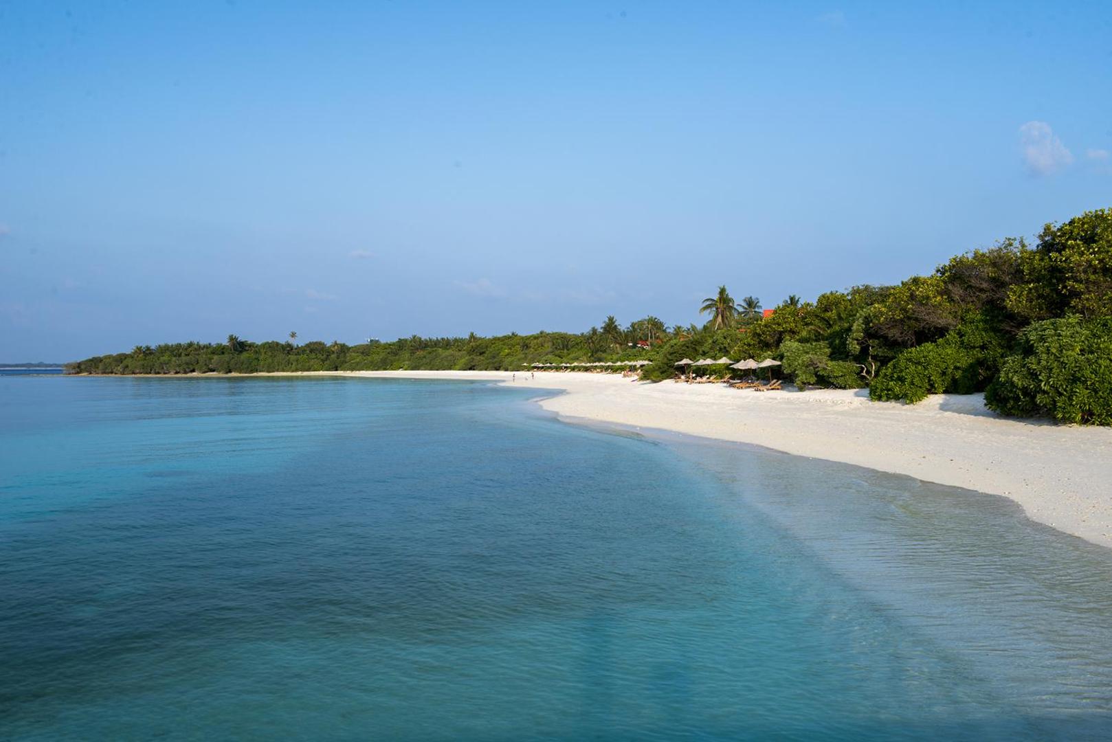 The Barefoot Eco Hotel privātā pludmale ar baltām smiltīm un tirkīzzilu okeāna ūdeni Maldīvu salu piekrastē.