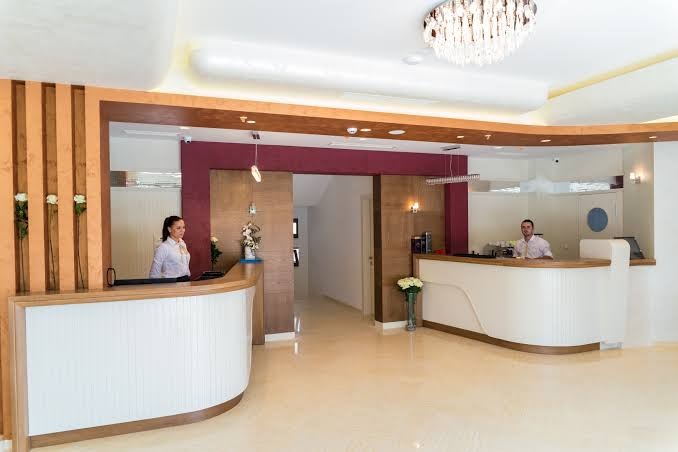 Kadmo by Aycon viesnīcas recepcijas zona ar modernu dizainu, baltām letēm un laipnu personālu Budvas kūrortā