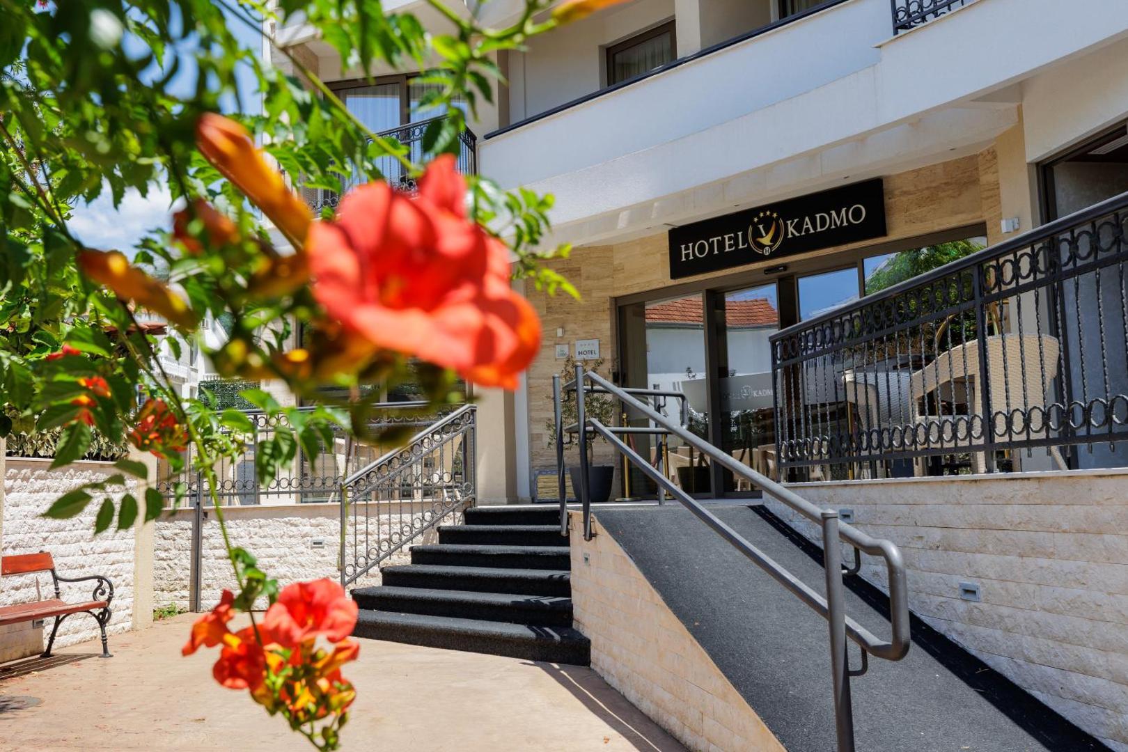 Viesnīcas Hotel Kadmo by Aycon ieeja ar kāpnēm, pandusu un ziedošiem krūmiem priekšplānā Budvas kūrortā