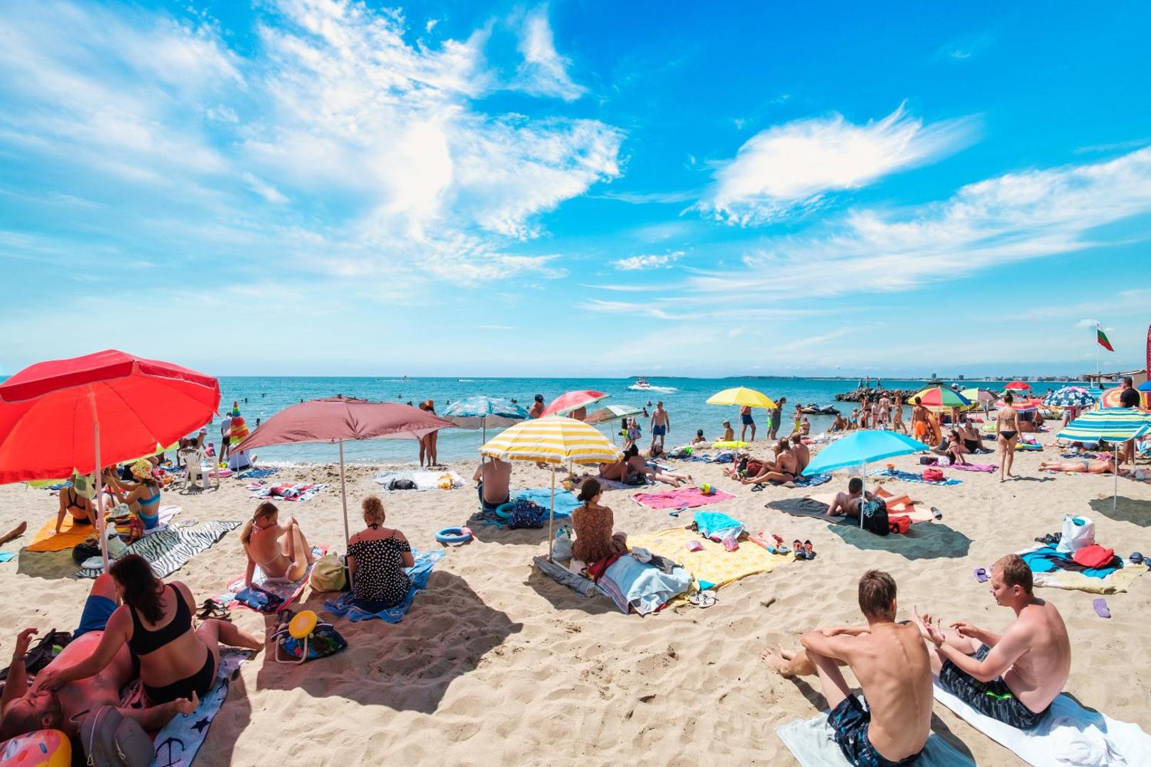 Premier Fort Beach Hotel publiskā pludmales zona ar krāsainiem saulessargiem un atpūtniekiem pie Melnās jūras Saulainajā krastā