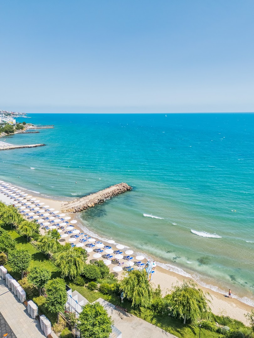 Premier Fort Beach Hotel privātā smilšu pludmale ar sauļošanās krēsliem un tirkīzzilu jūras ūdeni Sveti Vlasas kūrortā